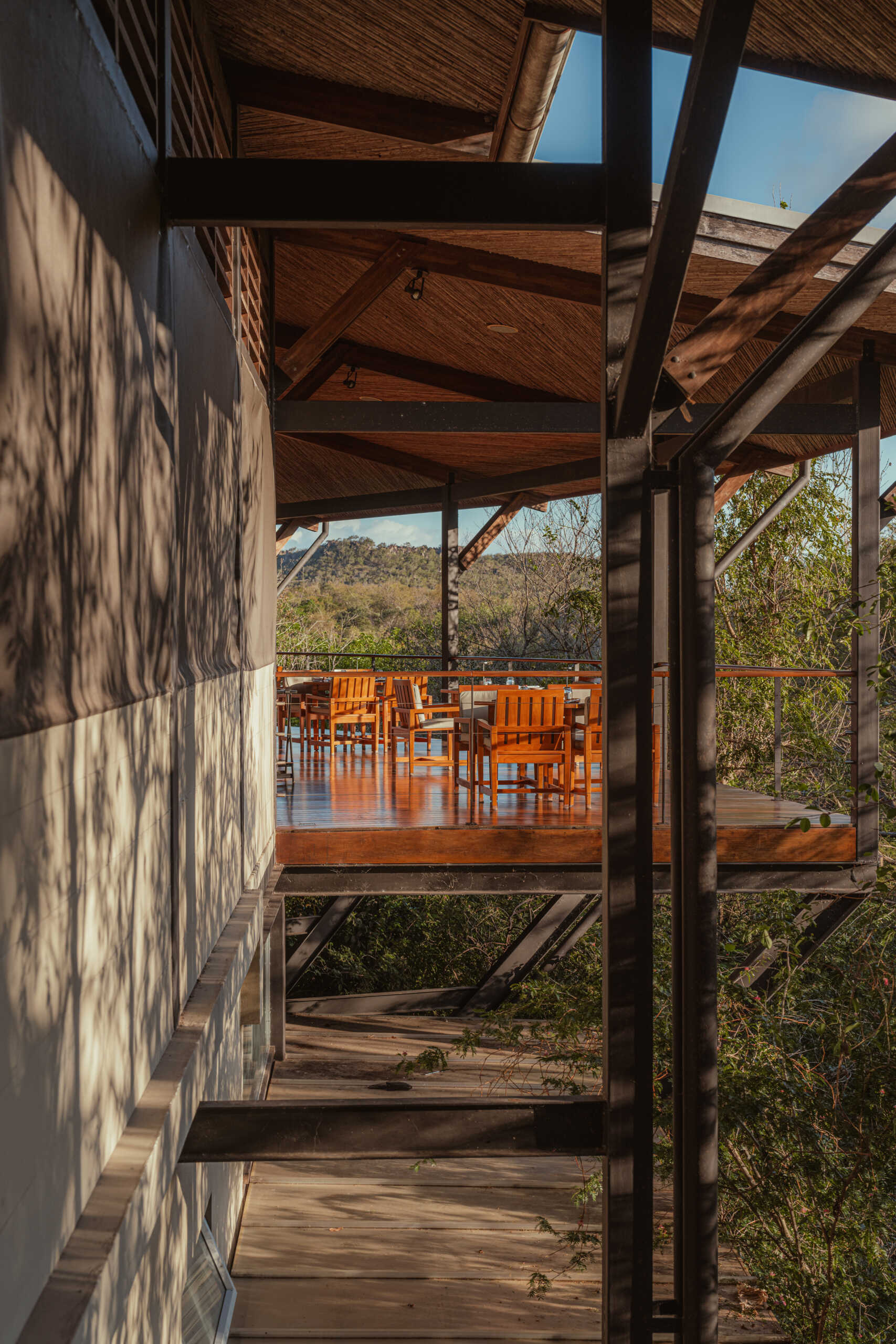 A stone, wood, and glass clad jungle bungalow in Costa Rica blends effortlessly into its forest surroundings.