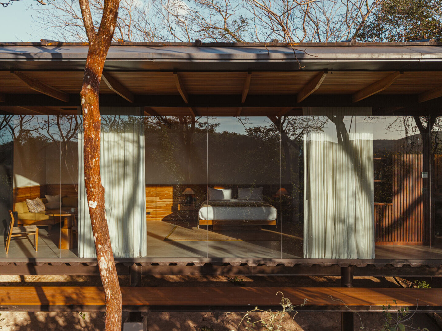 A stone, wood, and glass clad jungle bungalow in Costa Rica blends effortlessly into its forest surroundings.