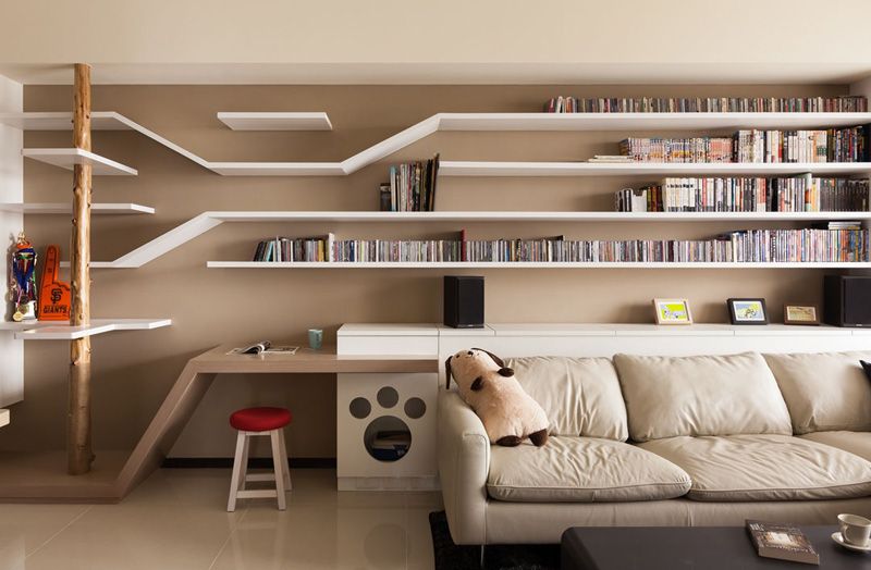Explore a seamless catwalk built into a bookshelf, combining clever storage with elevated paths for cats to climb and explore. A wooden scratching post and discreet litter box complete this thoughtful design.