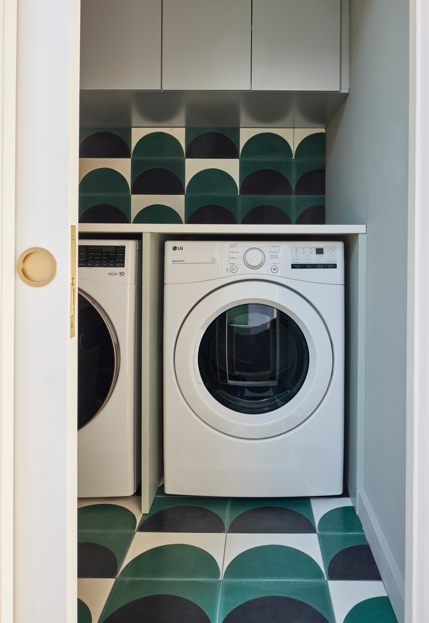 This laundry space brings character to the utilitarian, with patterned cement tiles in a bold anarch design, tying into the home’s larger material story.