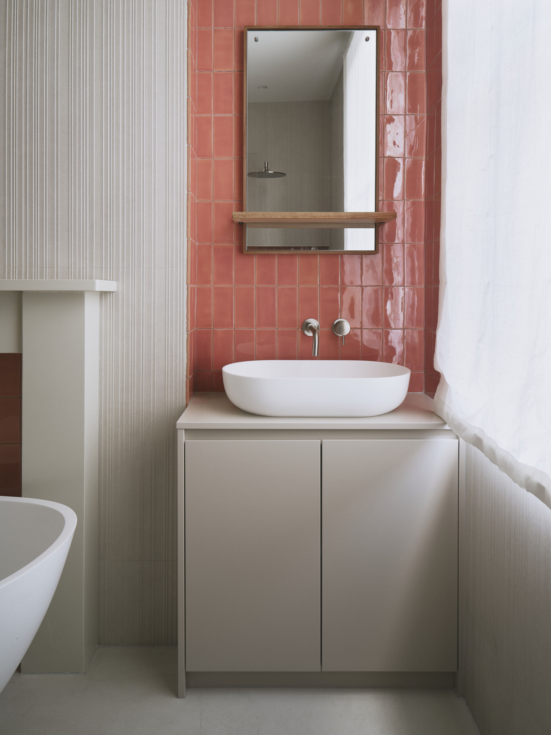 This bathroom blends old and new with glazed terracotta tiles, dual vanities, and a freestanding bathtub, all while keeping the space feeling calm and understated. Subtle textures and layered details add depth, and original features are reworked to quietly reflect the home’s Victorian roots.