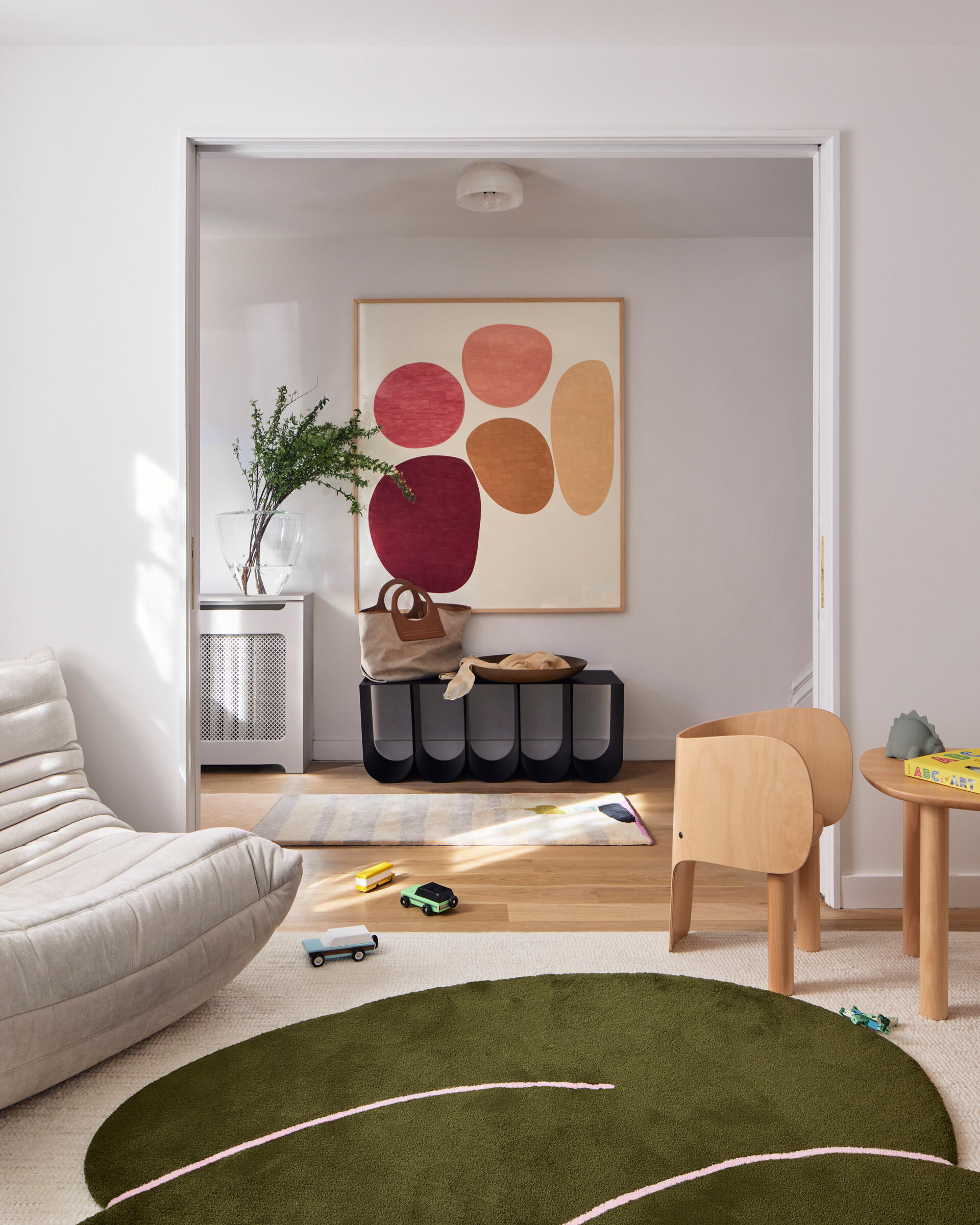 A bright, cheerful playroom sits at the top of the stairs, designed as a flexible, light-filled space for creativity and lounging.
