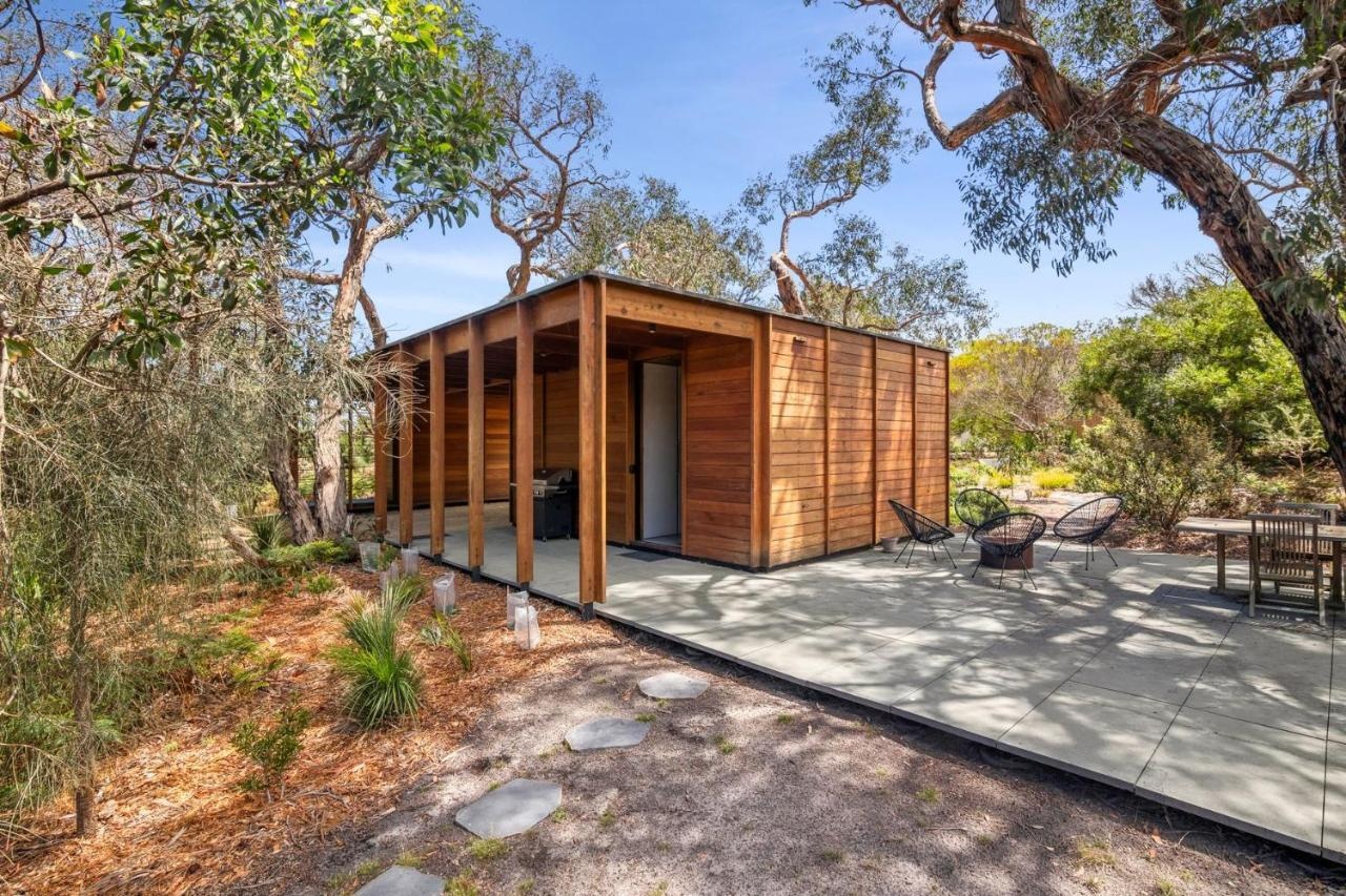 A recycled timber home and studio built with passive solar principles and reclaimed materials. It features two pavilions, full-height glazing, and a bluestone terrace set beneath native trees.