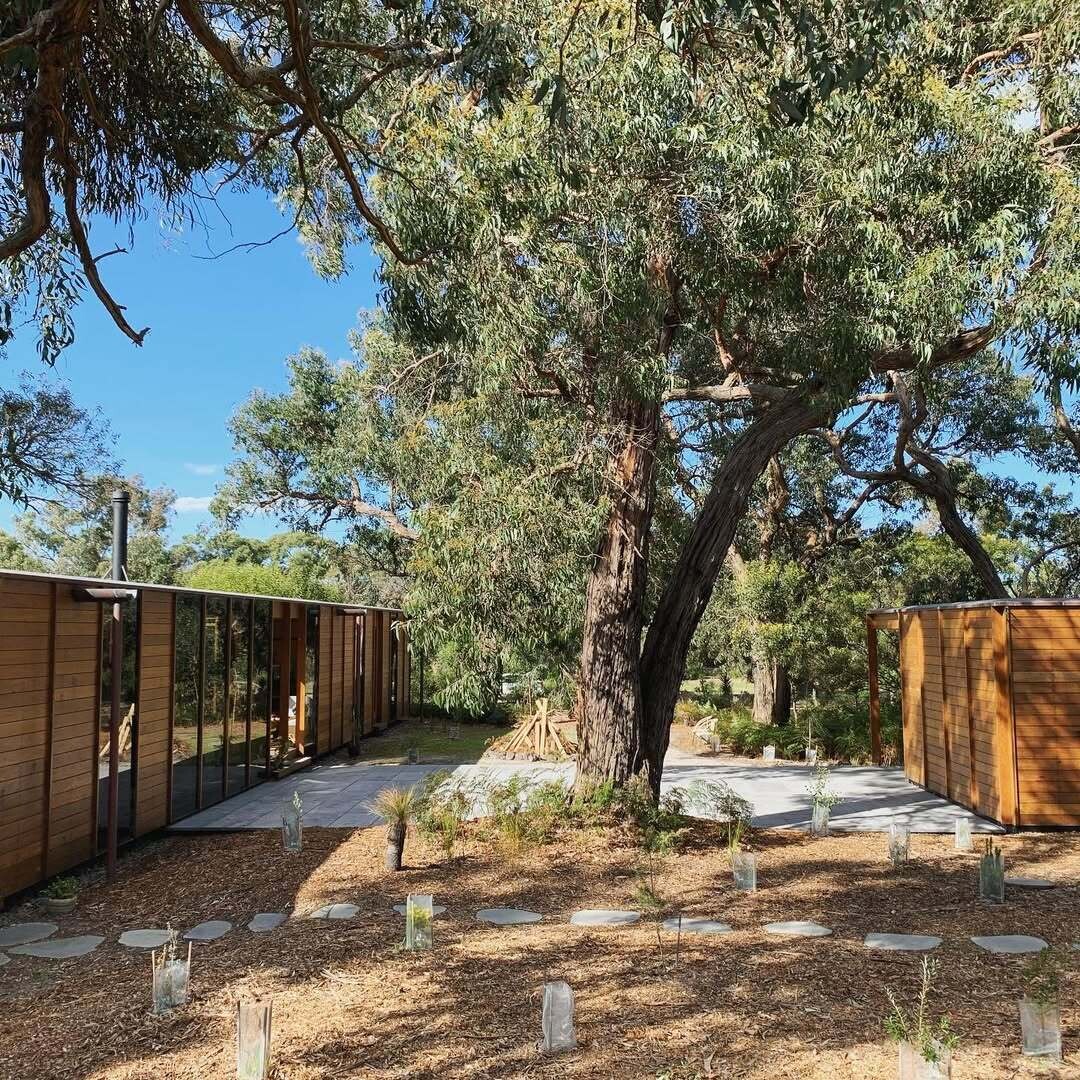 A recycled timber home and studio built with passive solar principles and reclaimed materials. It features two pavilions, full-height glazing, and a bluestone terrace set beneath native trees.