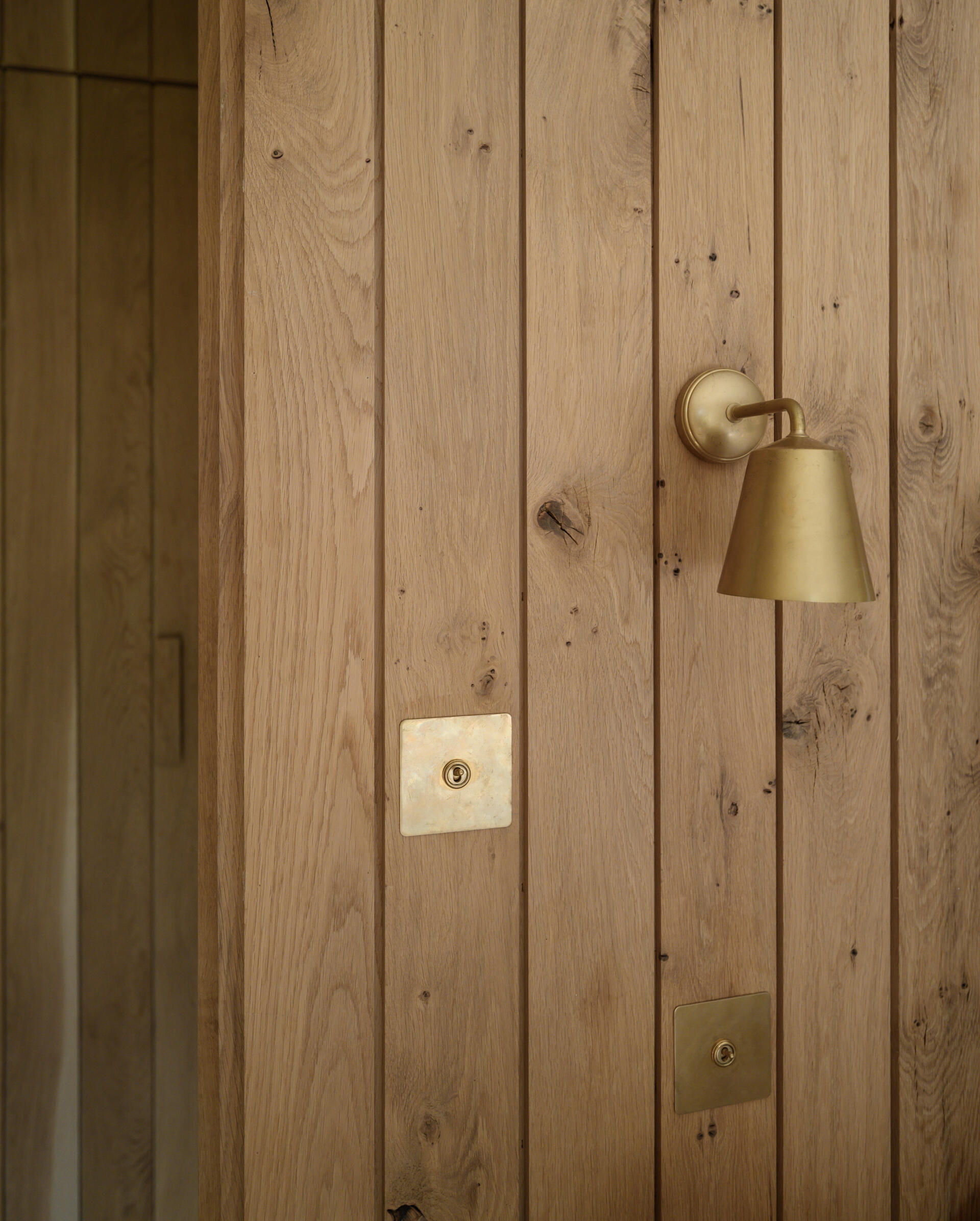 The guest bedroom is nestled into one side of the renovated barn, and is a simple, quiet space with a neutral palette, designed to feel both welcoming and private. Raw finishes and restrained styling keep the attention on the beautiful old structure.
