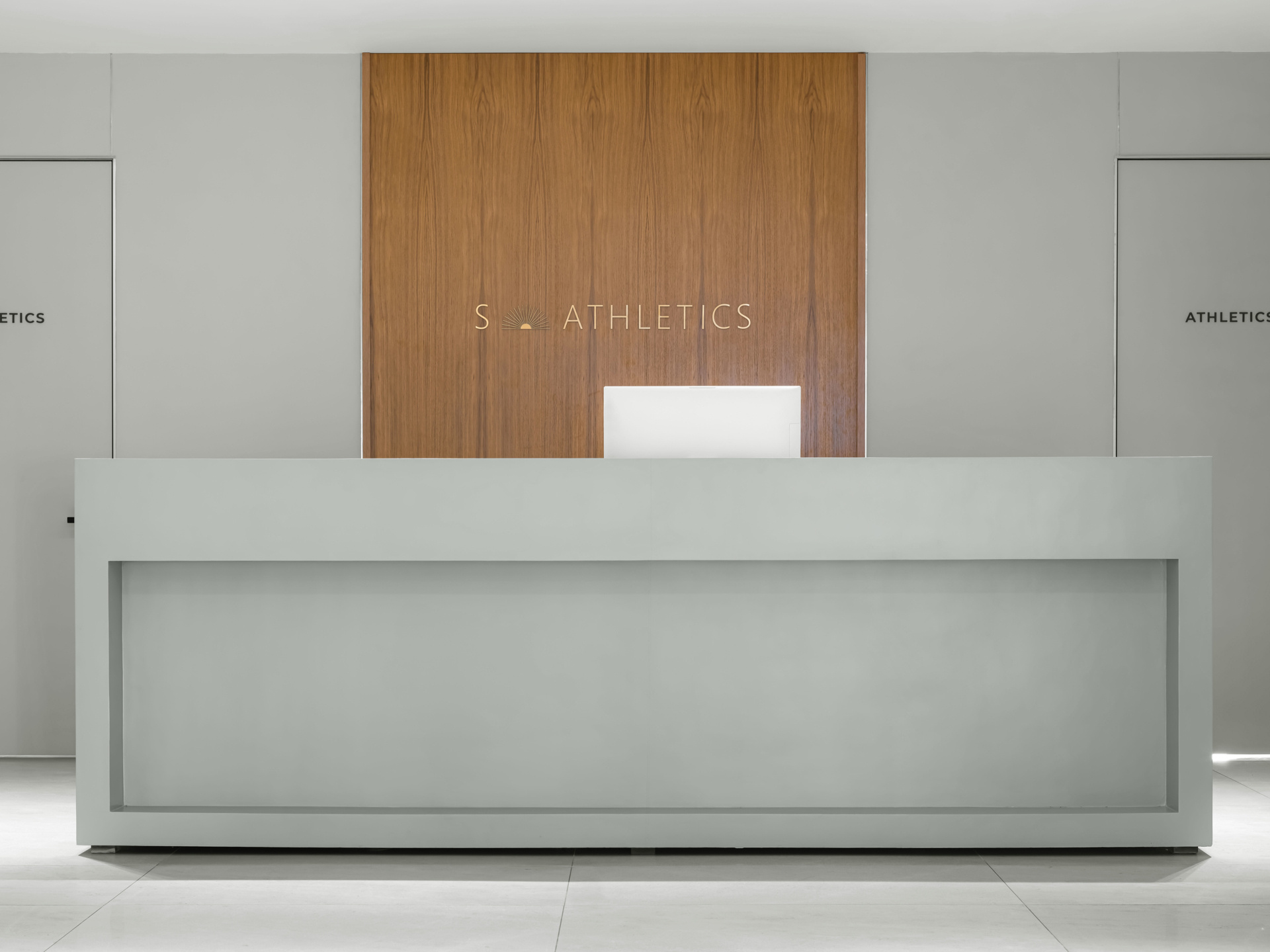 The second floor of SIAM SPA takes on a more minimalist mood with smooth grey walls, veined wood accents, and lush greenery. Custom wooden fitness equipment blends beauty with function, offering a serene environment for stretching, strength, and movement.