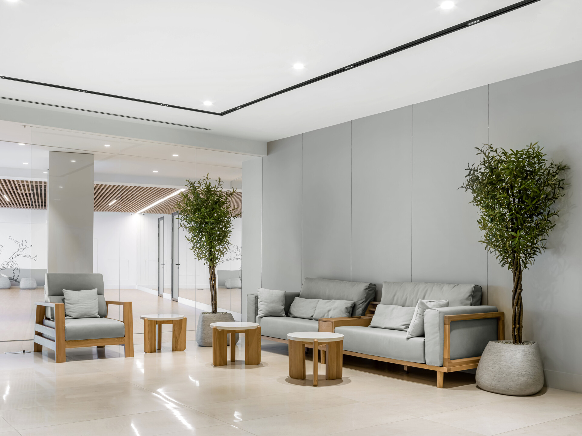 The second floor of SIAM SPA takes on a more minimalist mood with smooth grey walls, veined wood accents, and lush greenery. Custom wooden fitness equipment blends beauty with function, offering a serene environment for stretching, strength, and movement.