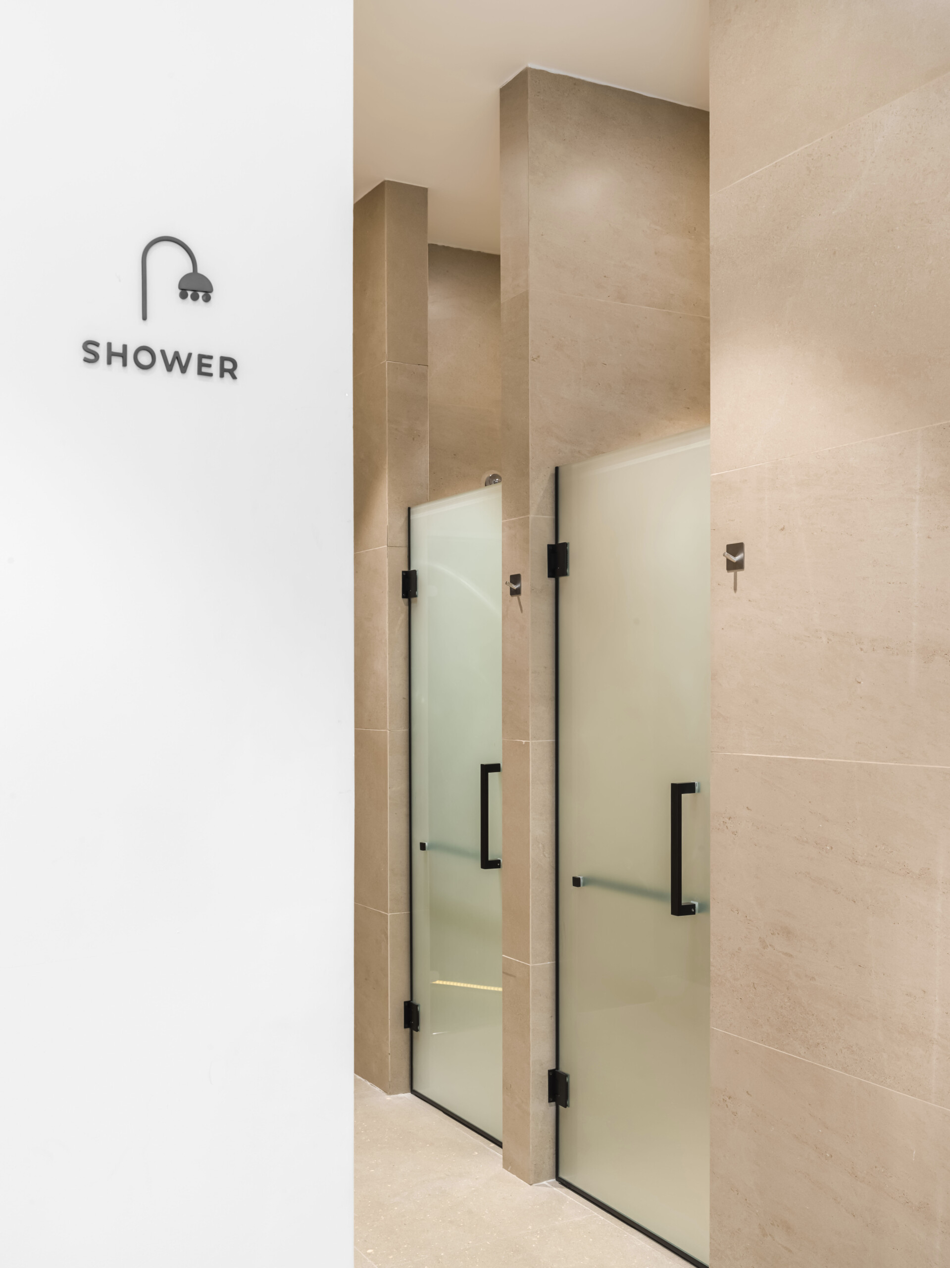 The second floor of SIAM SPA takes on a more minimalist mood with smooth grey walls, veined wood accents, and lush greenery. Custom wooden fitness equipment blends beauty with function, offering a serene environment for stretching, strength, and movement.