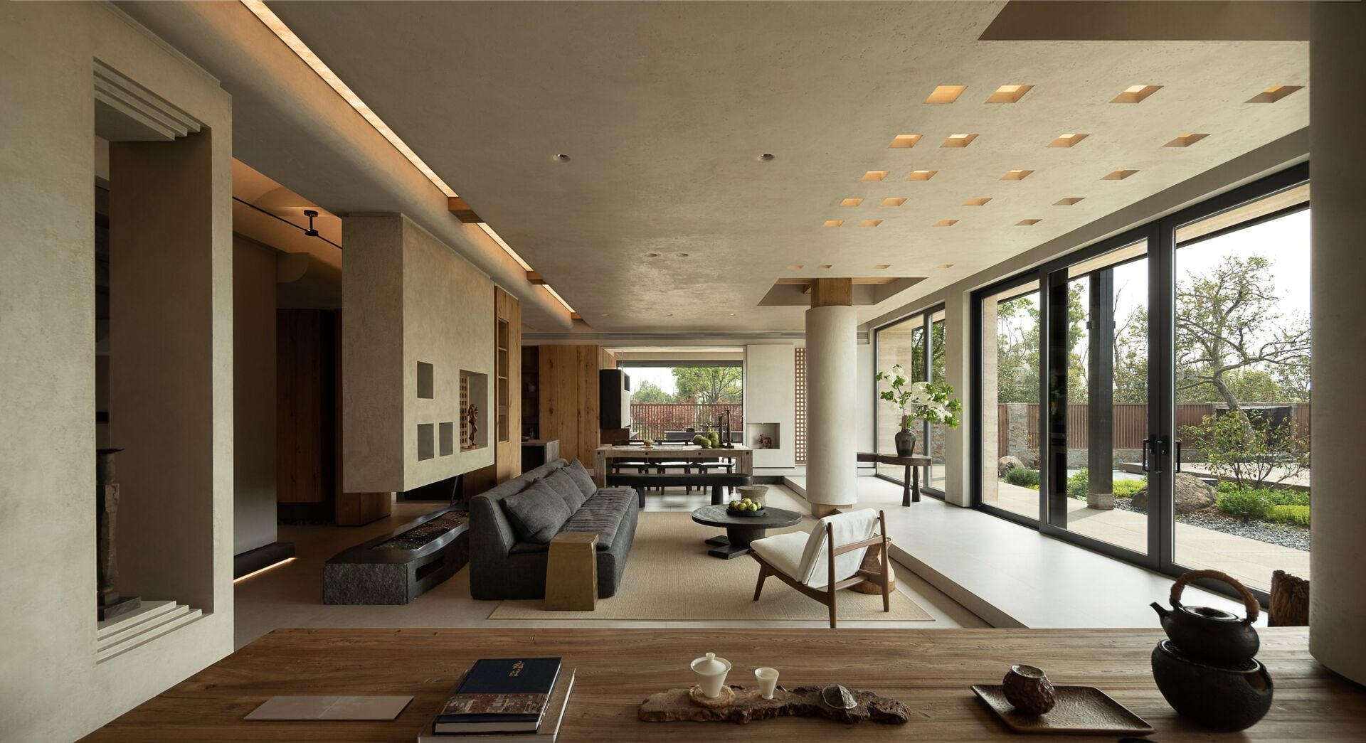 Earthy and refined, the living and dining space embraces elegance rooted in natural materials. One end of the open plan living room is where you'll find the dining area, while the other end is home to a solid wood table, anchored by sculptural bases in stone and organic wood.