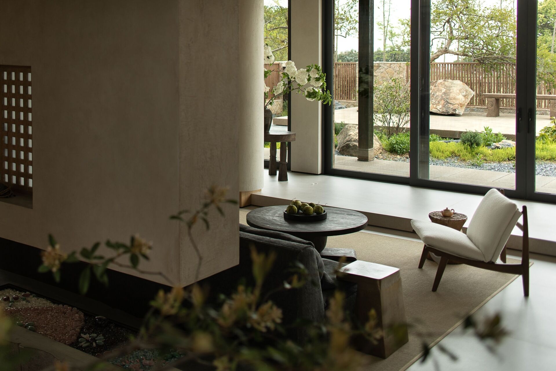Earthy and refined, the living and dining space embraces elegance rooted in natural materials. One end of the open plan living room is where you'll find the dining area, while the other end is home to a solid wood table, anchored by sculptural bases in stone and organic wood.