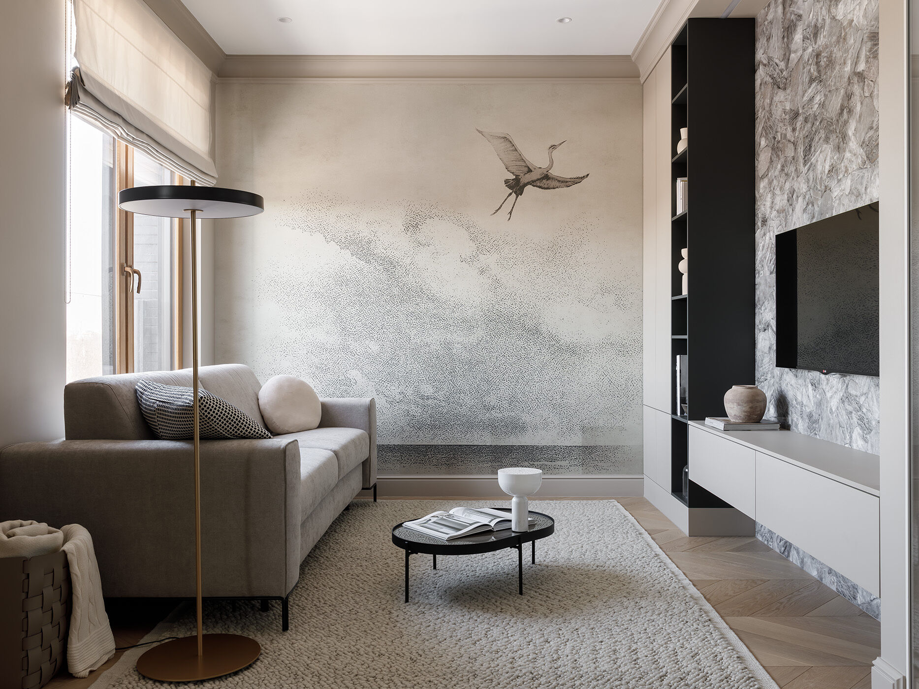 In the living room, a bold stork mural sets the tone, a symbol of happiness and family. A sculpted wood coffee table echoes the bird’s natural habitat, while soft light, a Felis sofa, and Danish accents complete the calm, layered look.