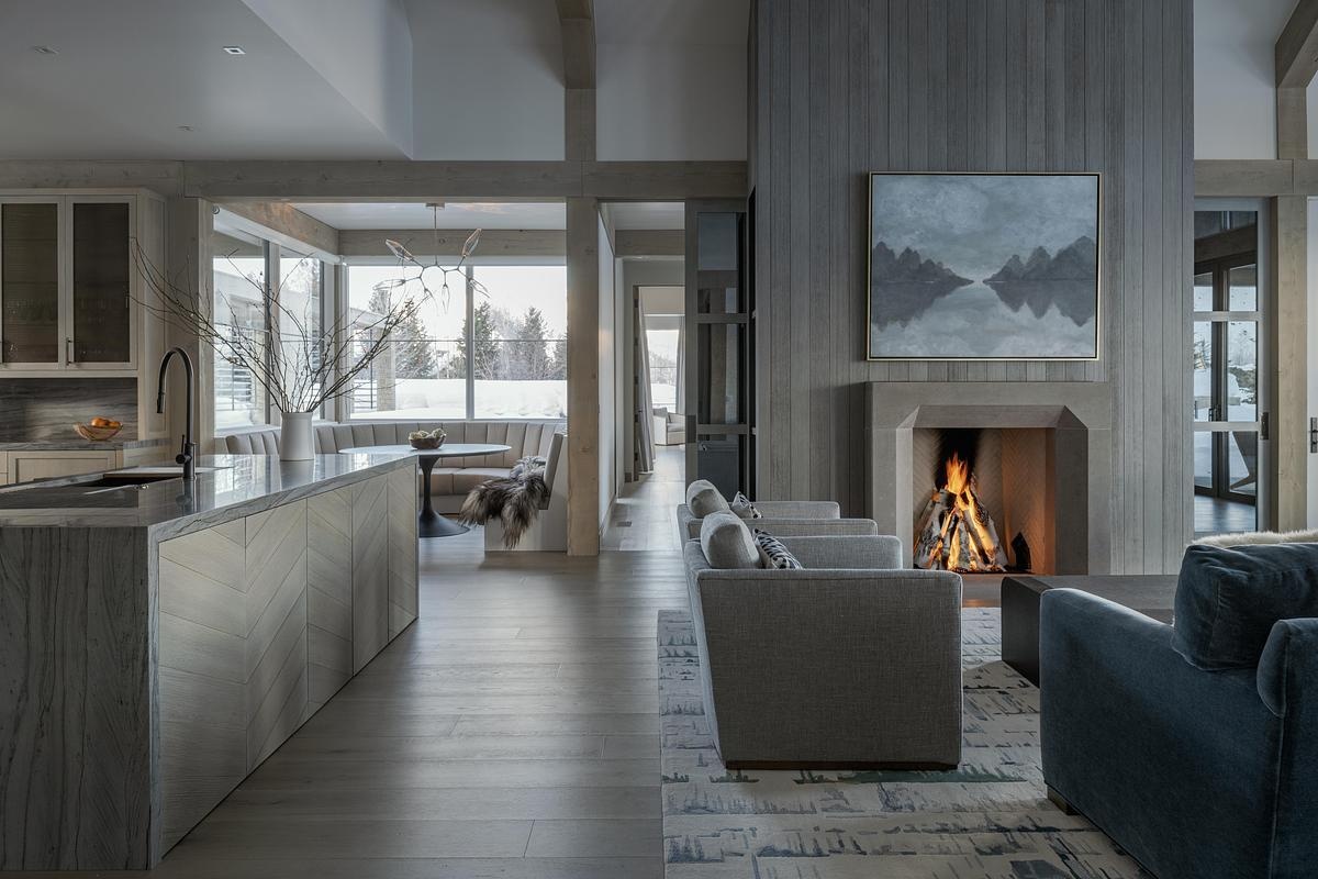 A softly lit living room with a fireplace, has been designed with natural textures.