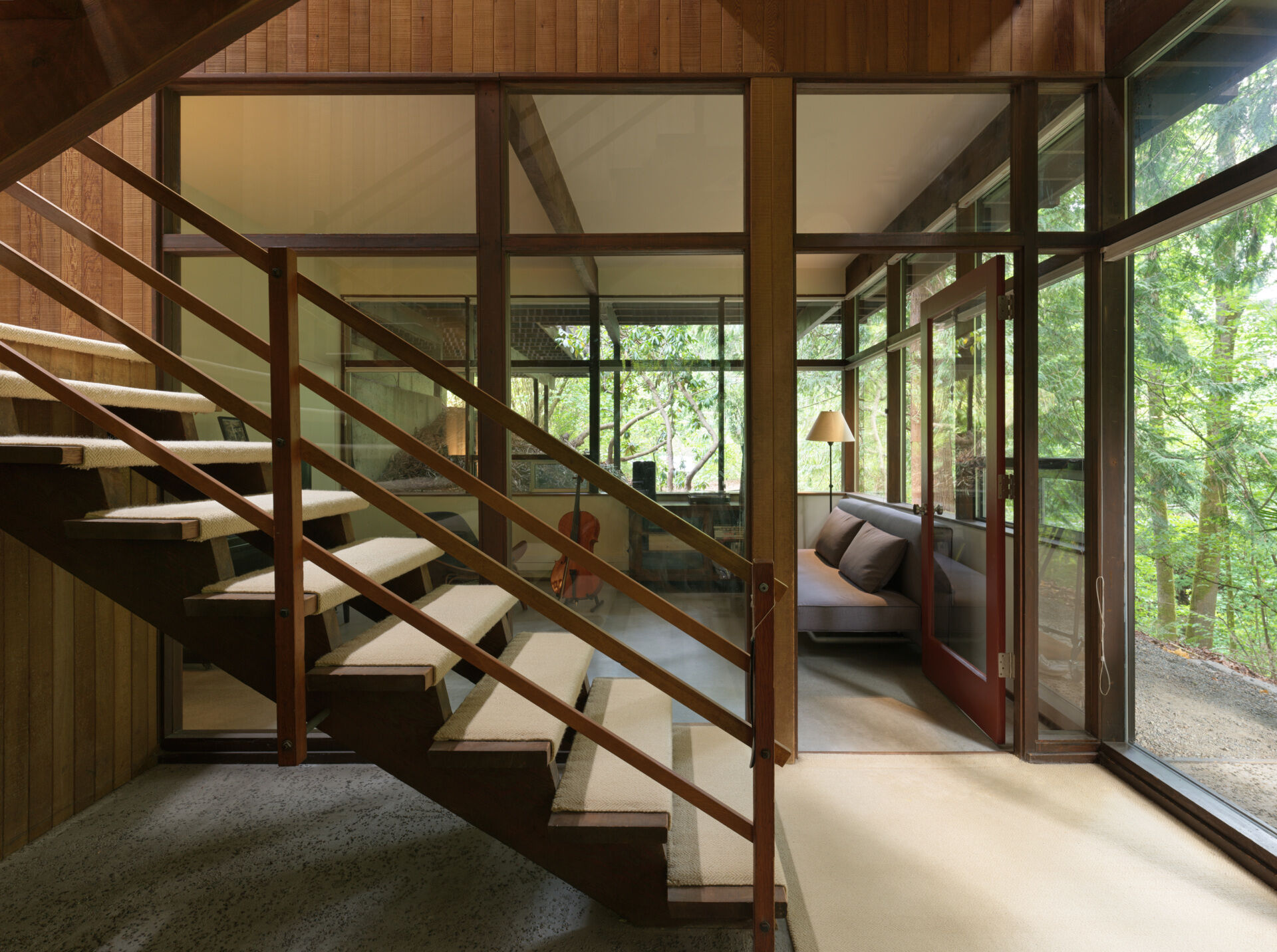  Once a studio for Alden Mason, this creative corner of the Mid-Century Modern home now serves as a music room. Nearby, the open-tread stairs rise through sunlight beneath a bold Rauschenberg print.
