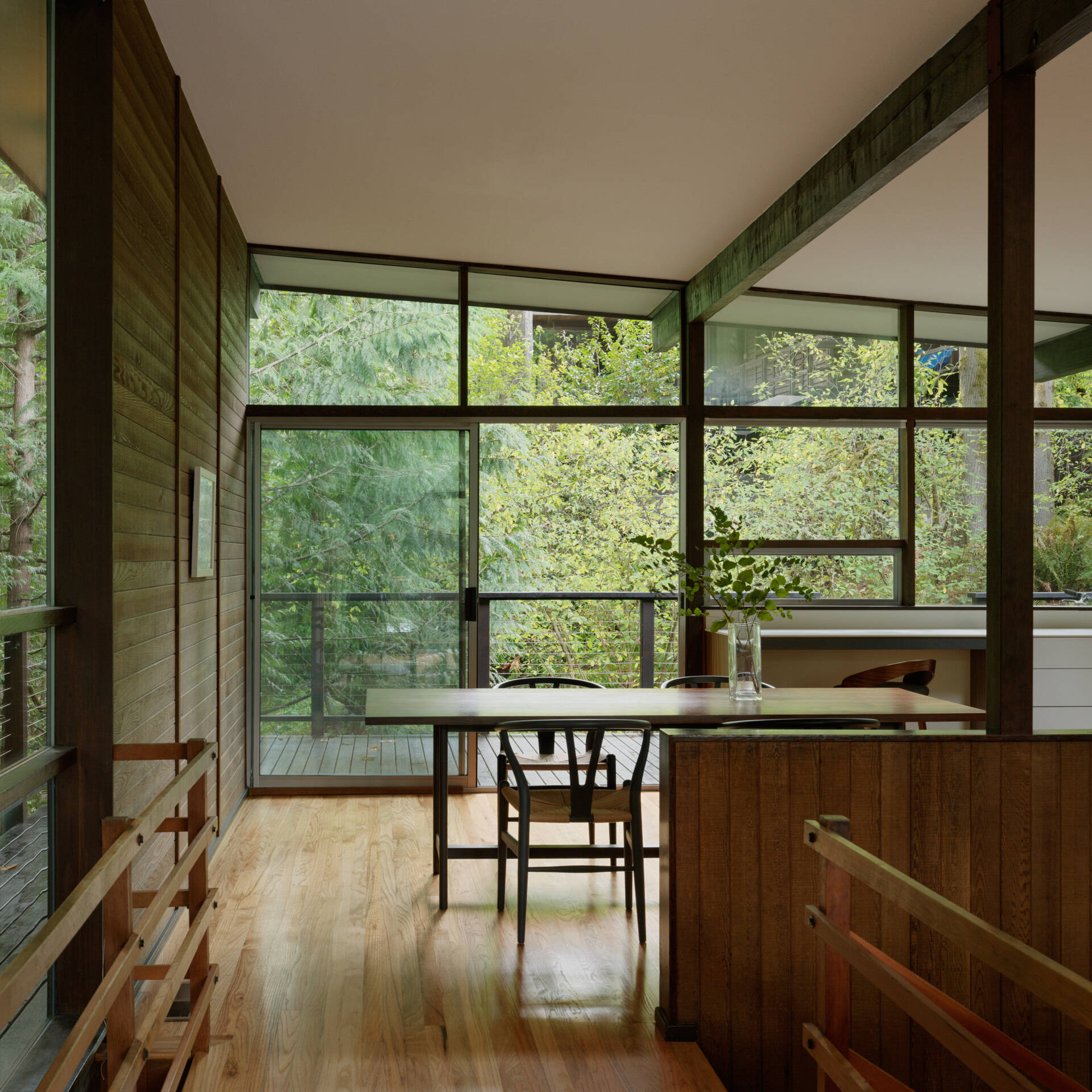 A curated Mid-Century Modern dining room featuring art by Do Ho Suh, a handcrafted Chadhaus table, and panoramic woodland views. It’s calm, warm, and built for connection.