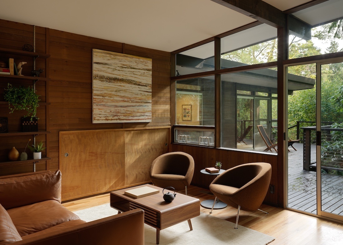  This Mid-Century Modern living room blends art and architecture with floor-to-ceiling windows, a striking steel fireplace, and original works by Alden Mason. Nature and design meet in a space full of light and intention.