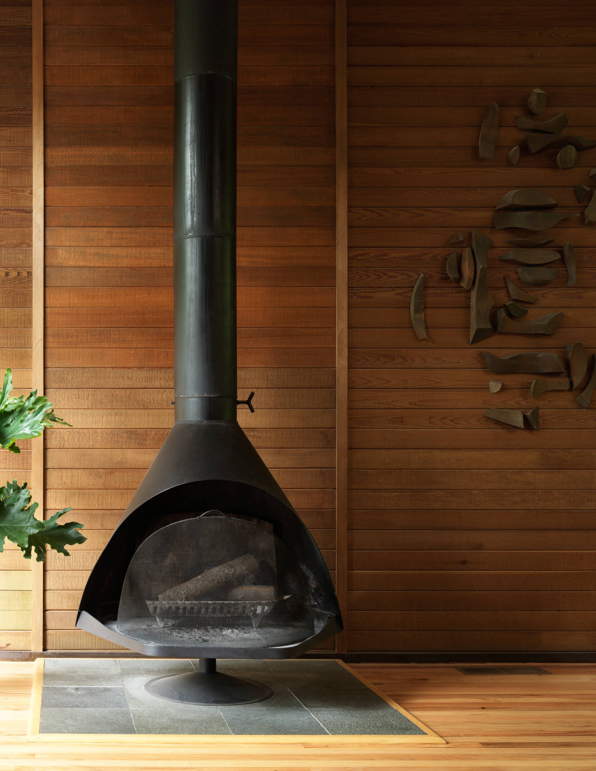  This Mid-Century Modern living room blends art and architecture with floor-to-ceiling windows, and a striking steel fireplace. Nature and design meet in a space full of light and intention.