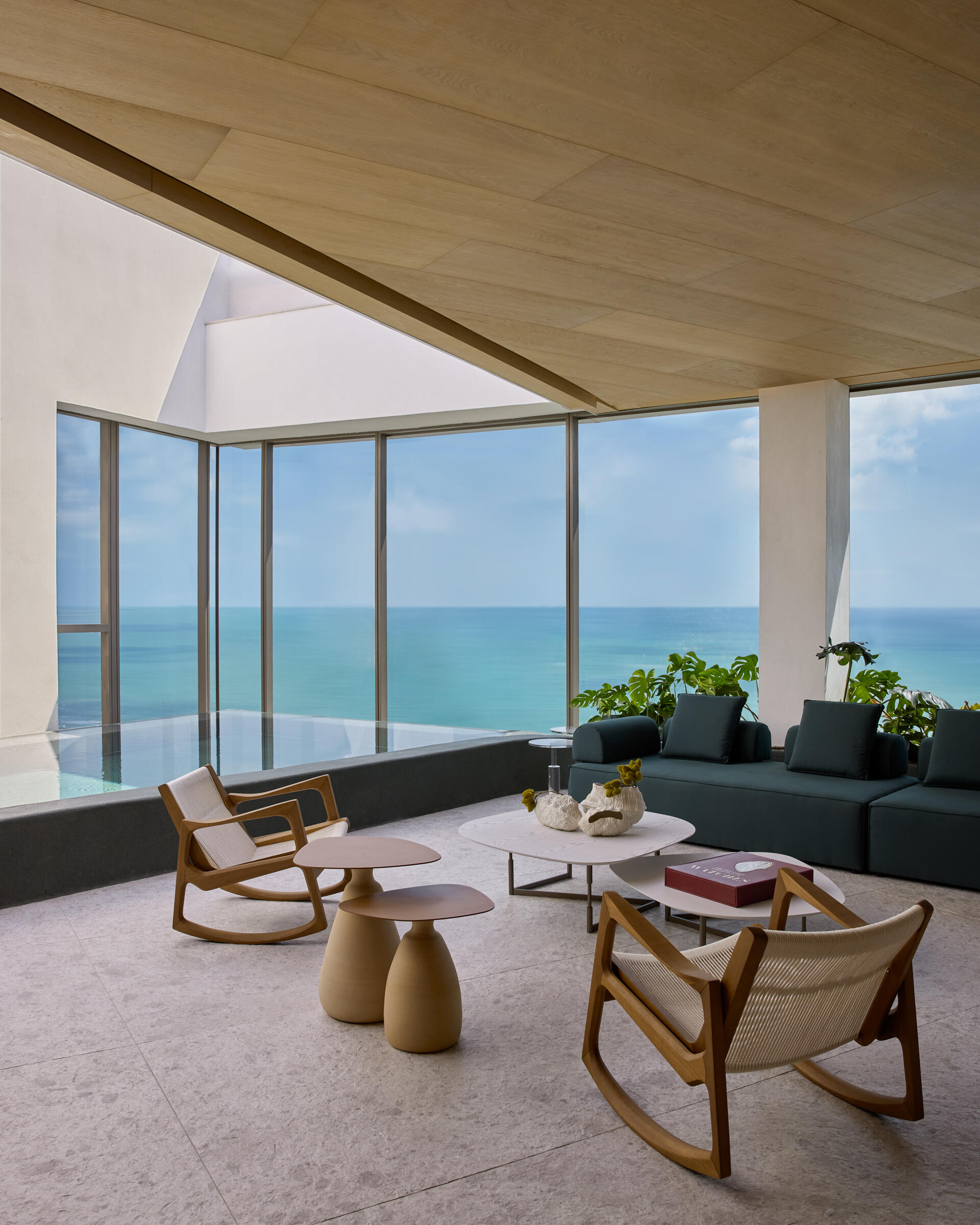 A pool, located on the upper floor of the duplex, is elevated to create an infinity edge effect mirroring the ocean.