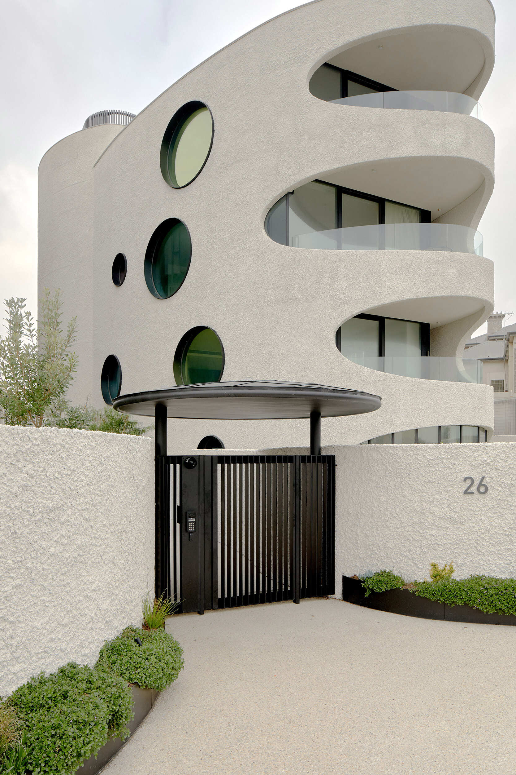 Sculptural apartment forms at Esplanade Brighton step down toward the coast, blending into the urban grain while standing out through bold material choices and curved, contemporary design.