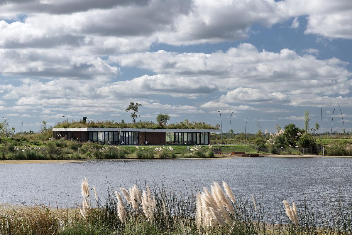 This concrete shell of this modern club house does double duty: it acts as both the building’s structure and surface, minimizing visual clutter and material use. The result is a continuous architectural form that feels quiet yet confident, merging seamlessly with its environment while inviting people to explore, gather, and linger.
