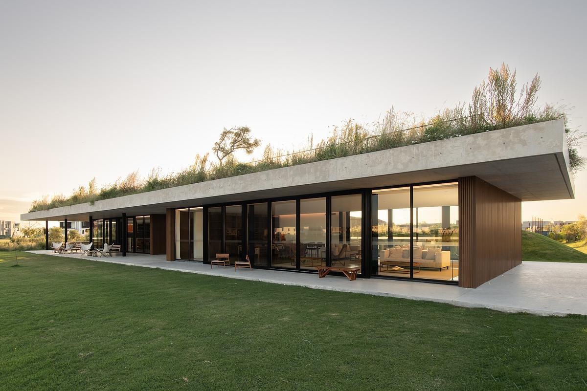 This concrete shell of this modern club house does double duty: it acts as both the building’s structure and surface, minimizing visual clutter and material use. The result is a continuous architectural form that feels quiet yet confident, merging seamlessly with its environment while inviting people to explore, gather, and linger.