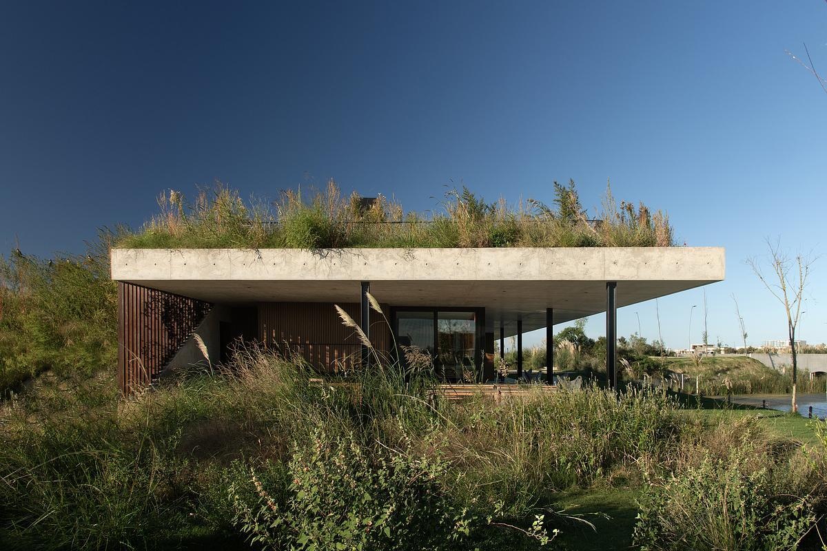 This concrete shell of this modern club house does double duty: it acts as both the building’s structure and surface, minimizing visual clutter and material use. The result is a continuous architectural form that feels quiet yet confident, merging seamlessly with its environment while inviting people to explore, gather, and linger.