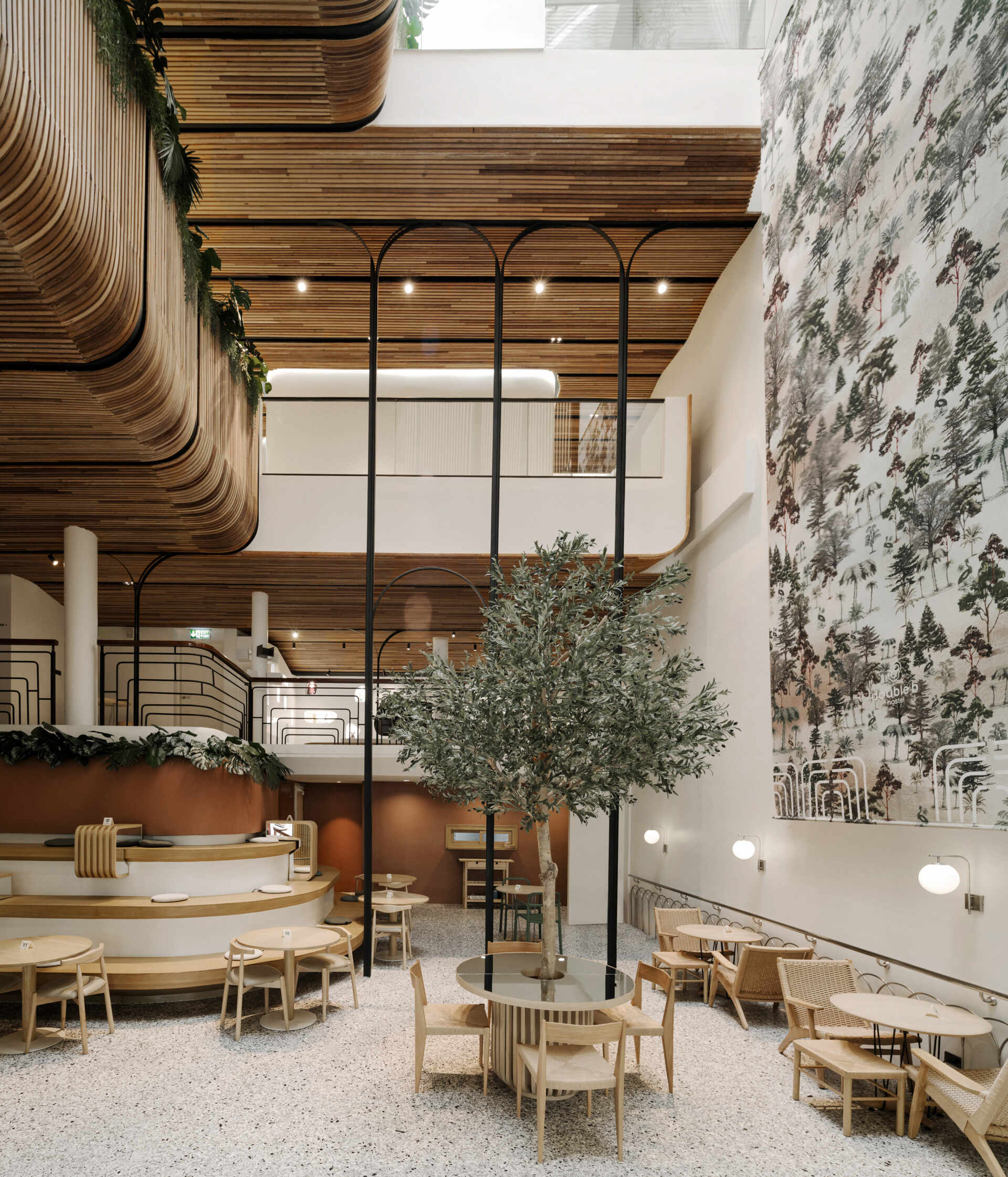 At the heart of the hostel, a light-filled internal courtyard with curved wooden facades and planted balconies offers a serene oasis amid the city’s tight urban fabric. There's also a cafe and tiered seating.