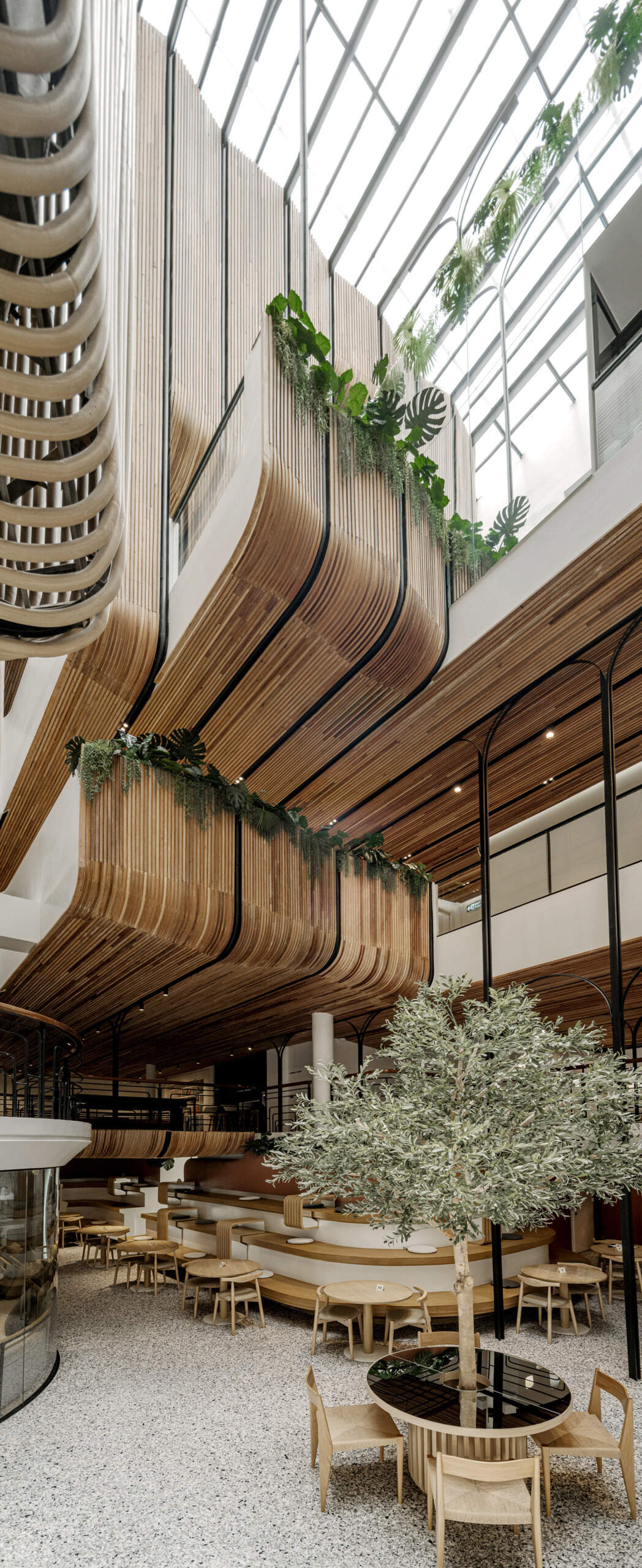 At the heart of the hostel, a light-filled internal courtyard with curved wooden facades and planted balconies offers a serene oasis amid the city’s tight urban fabric. There's also a cafe and tiered seating.