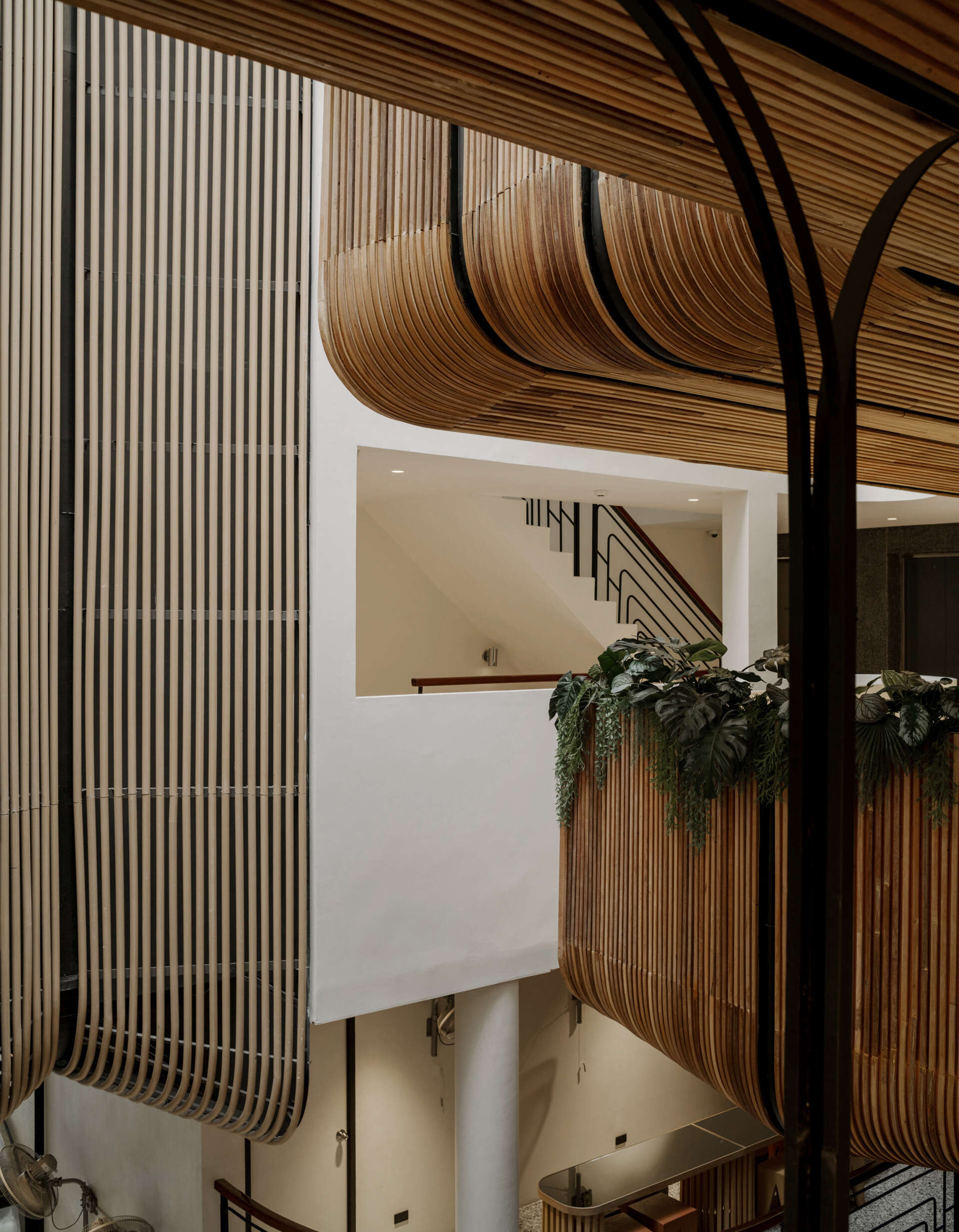 At the heart of the hostel, a light-filled internal courtyard with curved wooden facades and planted balconies offers a serene oasis amid the city’s tight urban fabric. There's also a cafe and tiered seating.
