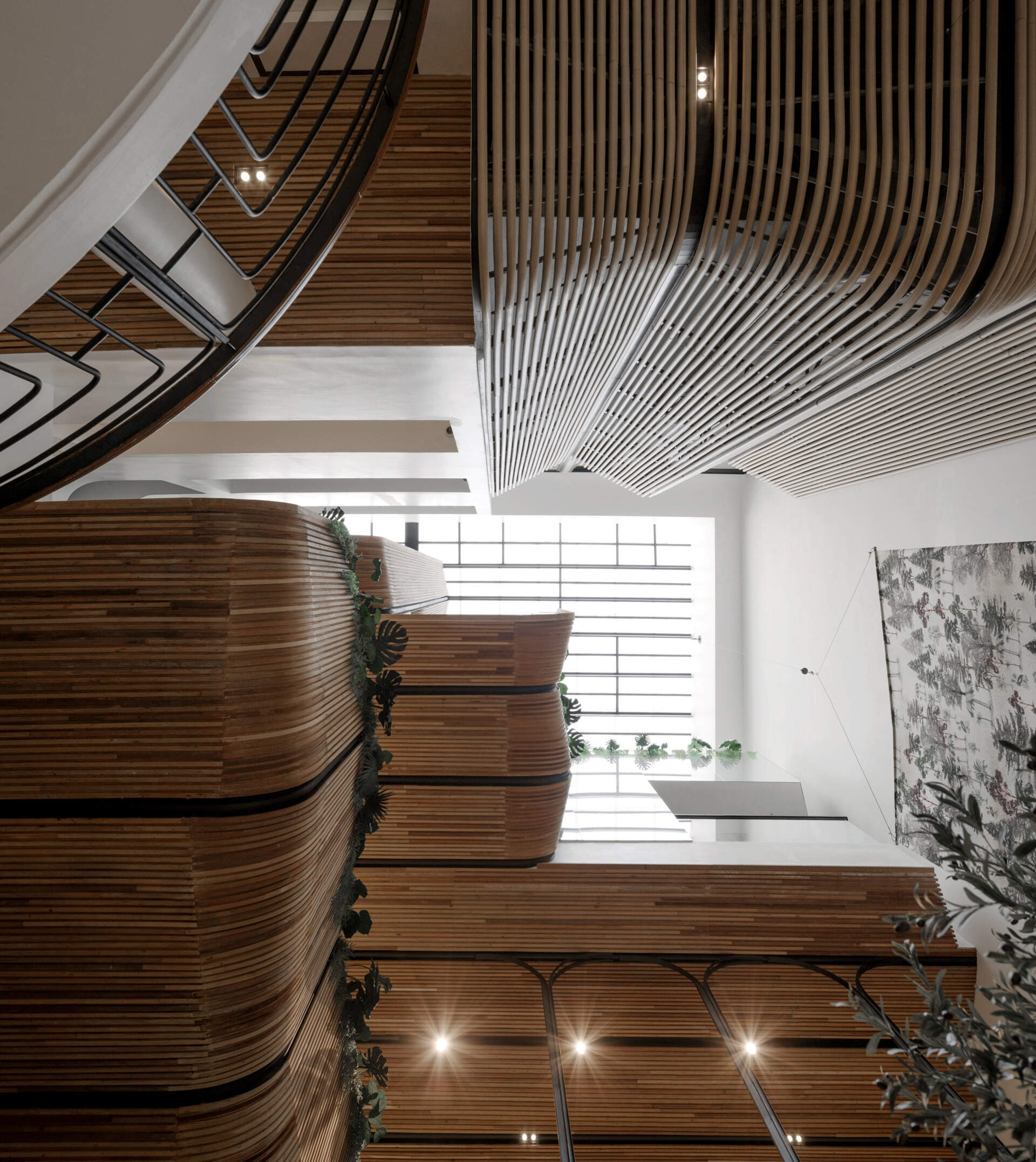 At the heart of the hostel, a light-filled internal courtyard with curved wooden facades and planted balconies offers a serene oasis amid the city’s tight urban fabric. There's also a cafe and tiered seating.