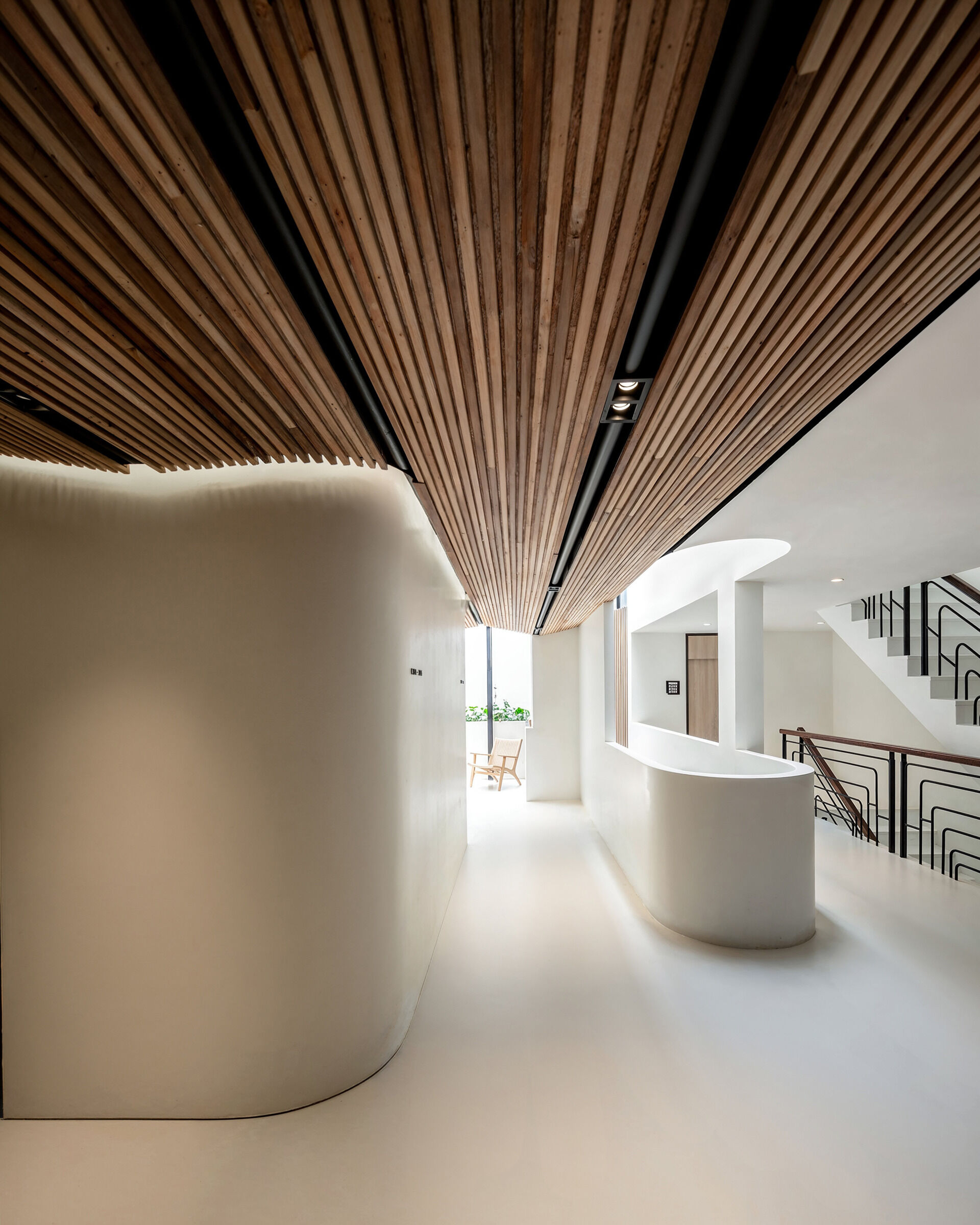 The hallways of this hostel carry through the warm, tactile quality established in the courtyard. Corridors are lined with reclaimed timber ceilings and soft lighting, creating a quiet, cocoon-like transition between public and private spaces.