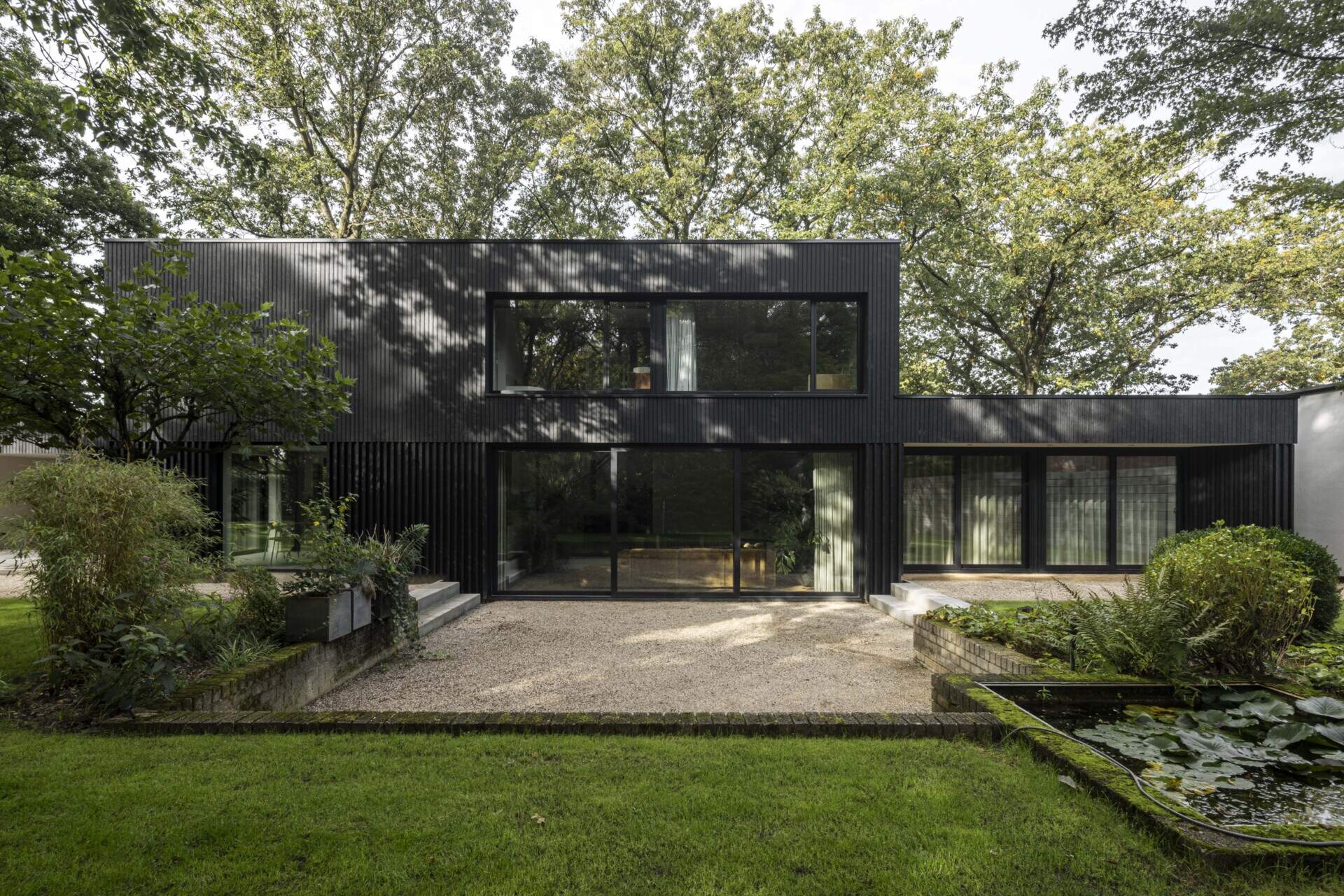 Within the bold silhouette of dark wood cladding, the layout of this modern home is open and fluid, with living spaces stretching across the ground floor and private rooms above.