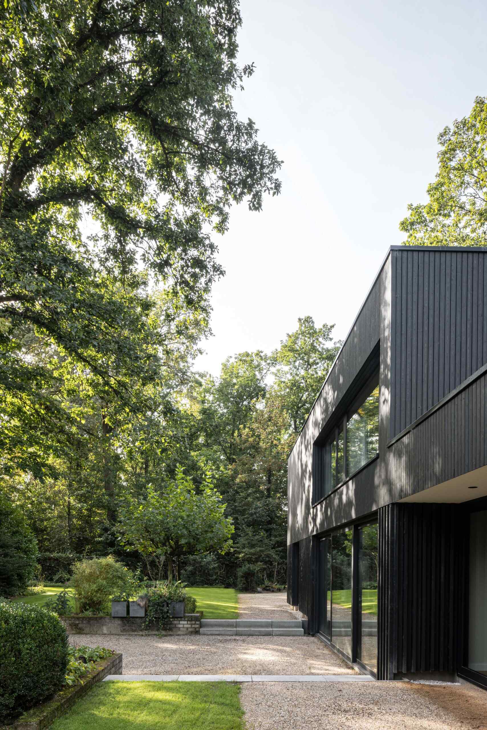 Within the bold silhouette of dark wood cladding, the layout of this modern home is open and fluid, with living spaces stretching across the ground floor and private rooms above.