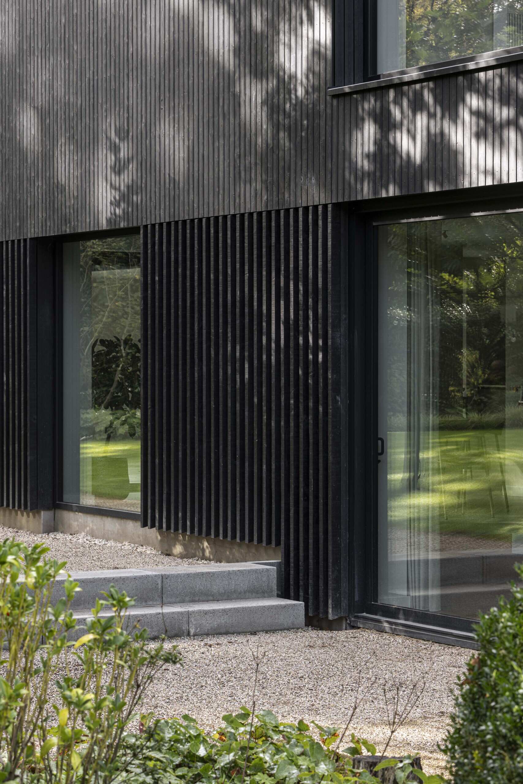 Within the bold silhouette of dark wood cladding, the layout of this modern home is open and fluid, with living spaces stretching across the ground floor and private rooms above.