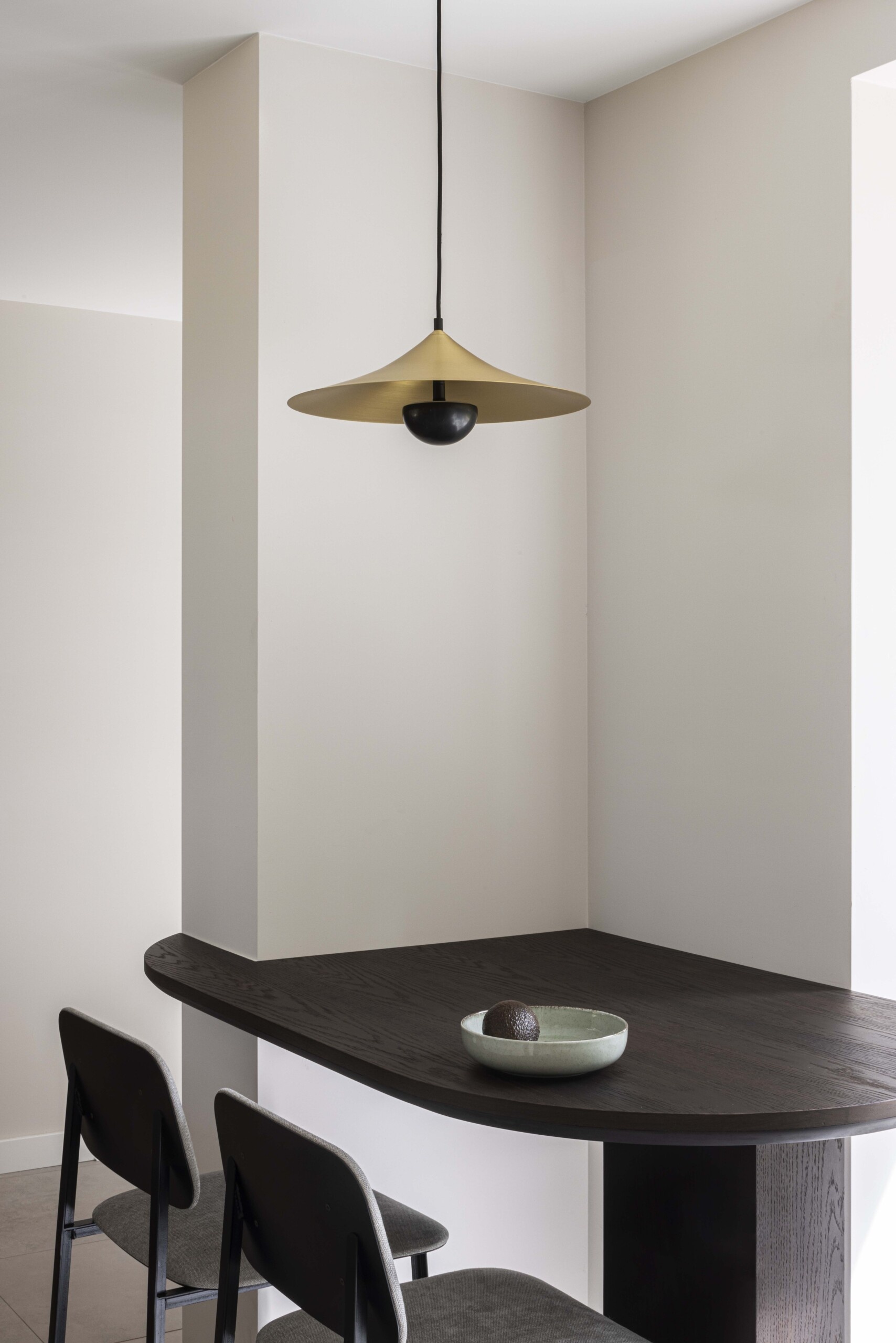 A quiet corner reimagined: this built-in kitchen breakfast bar combines sculptural elegance with everyday function. The dark wood surface, soft matte finishes, and minimalist pendant create a cozy nook that feels both modern and timeless.