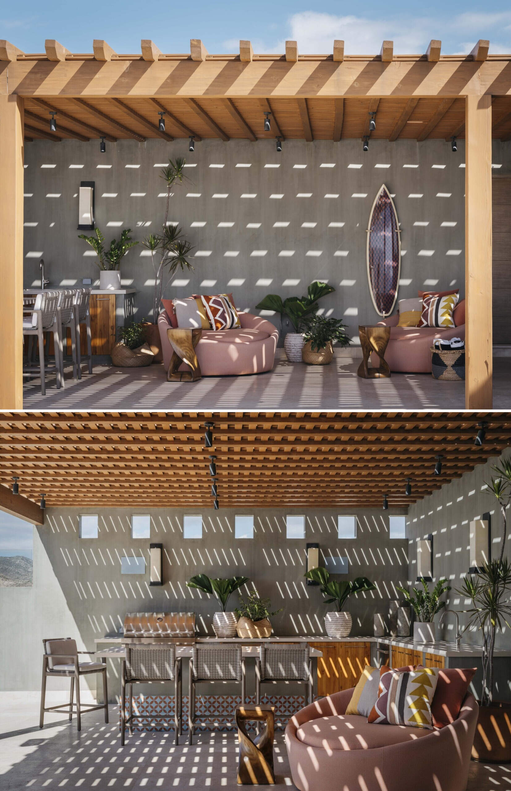 This outdoor lounge captures that perfect blend of sun-drenched and shaded, where the light filters through the slatted roof in a mesmerizing dance across every surface. The wood pergola feels warm and welcoming, casting patterned shadows that change with the day. A pair of circular loungers in soft desert rose invite you to sink in and stay awhile, their colorful pillows echoing the tones of clay, sand, and sunset. A surfboard-turned-art piece adds a playful, coastal energy to the concrete wall, while lush potted plants soften the space with their broad green leaves. A bar-height dining table and outdoor kitchen creates a casual gathering spot for afternoon snacks or late-night drinks. It’s a space that feels relaxed but intentional, built for lingering conversations and effortless outdoor living, all under an ever-shifting canopy of light and shadow.