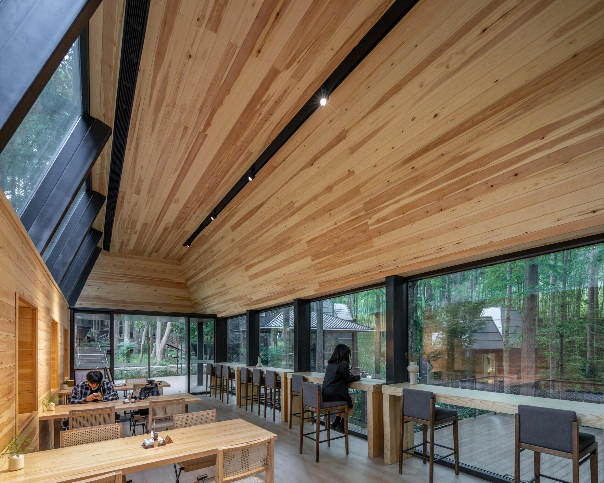 This modern reception space in a Hangzhou forest blurs the line between architecture and nature. Framed forest views and clerestory windows bring light and stillness into a structure shaped by the terrain.