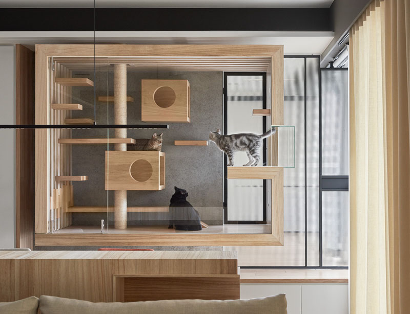 Discover a sleek glass-and-wood cat enclosure suspended to give cats stunning views of the balcony and beyond. This built-in design blends style with function, creating a cozy retreat for feline family members.