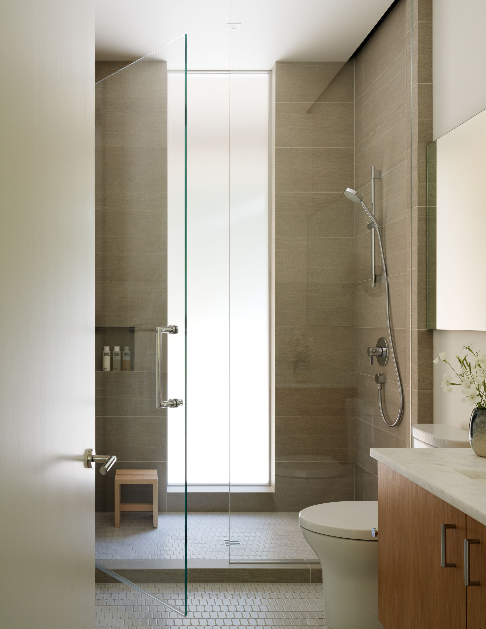 The guest bath continues the home’s themes of simplicity and resilience. Hard-wearing tile and clean-lined fixtures create a bathroom that can handle high traffic while remaining beautiful. The materials echo those found in the rest of the home.