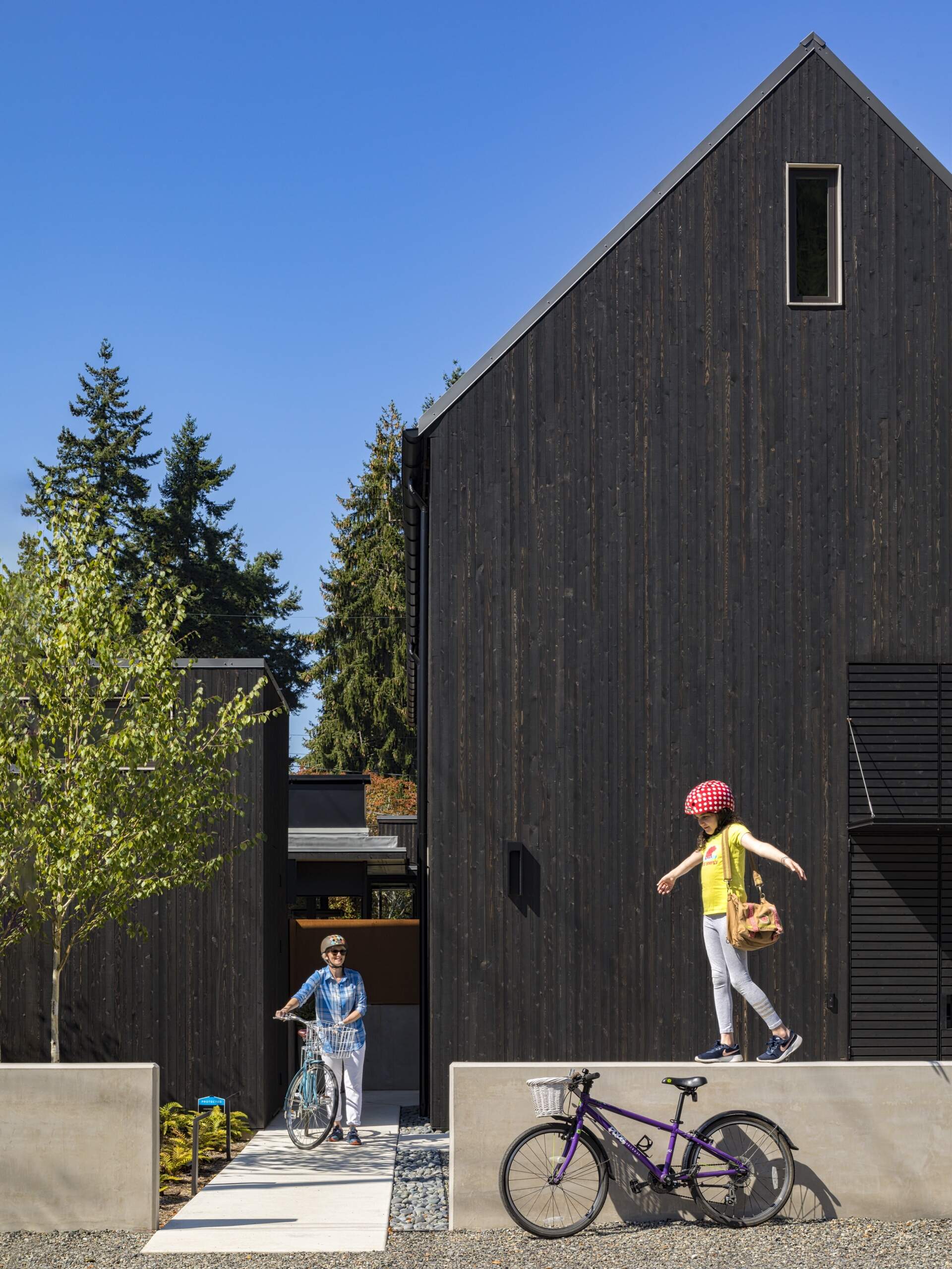 Exterior wood siding of this modern house is treated with black pine tar, creating a durable, textured finish that visually anchors the building. Corten steel accents add warmth and material contrast without disrupting the minimalist language.