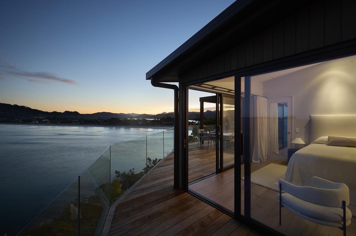 The timber decks wrap around the home, extending beyond the main living area and linking seamlessly to both bedrooms. This continuous circulation allows each bedroom to open directly to the surrounding landscape. Whether stepping out for morning sun or catching the evening breeze, the connection to nature is always just a few steps away.