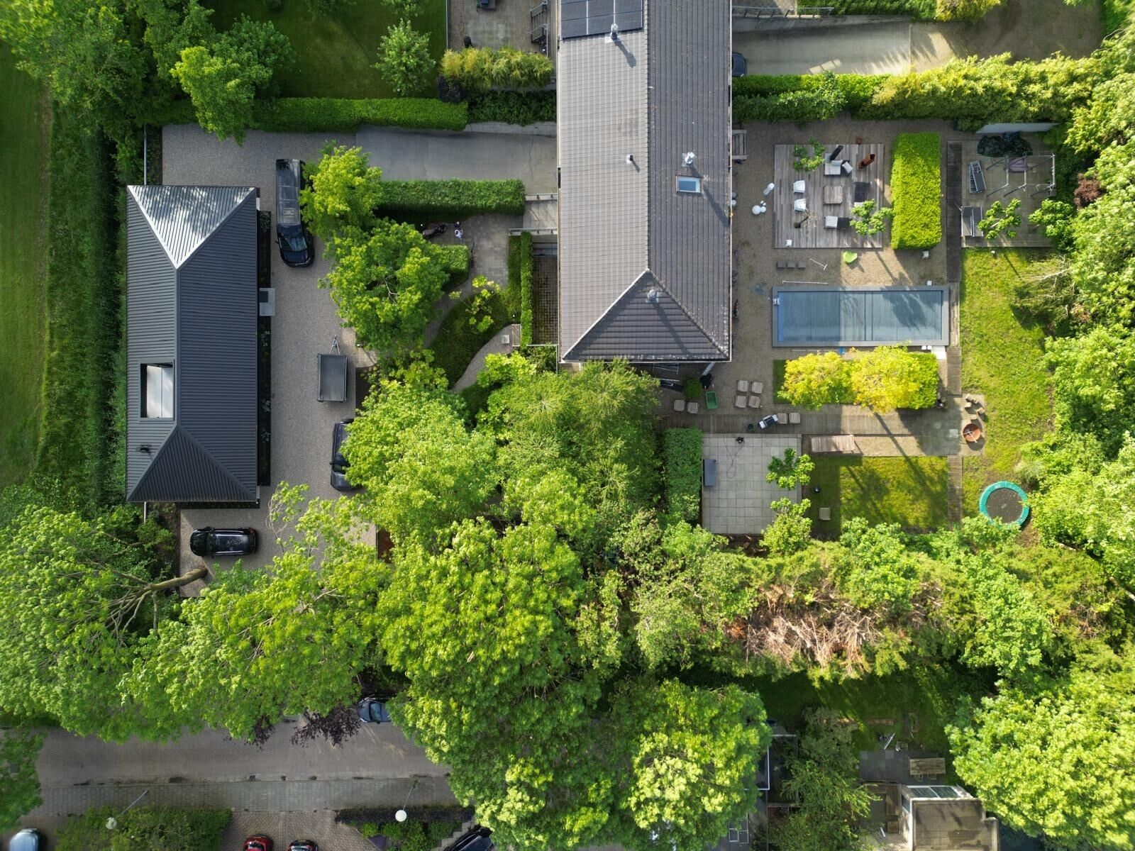 A modern and compact home with black waxed-wood cladding and extended rooflines.