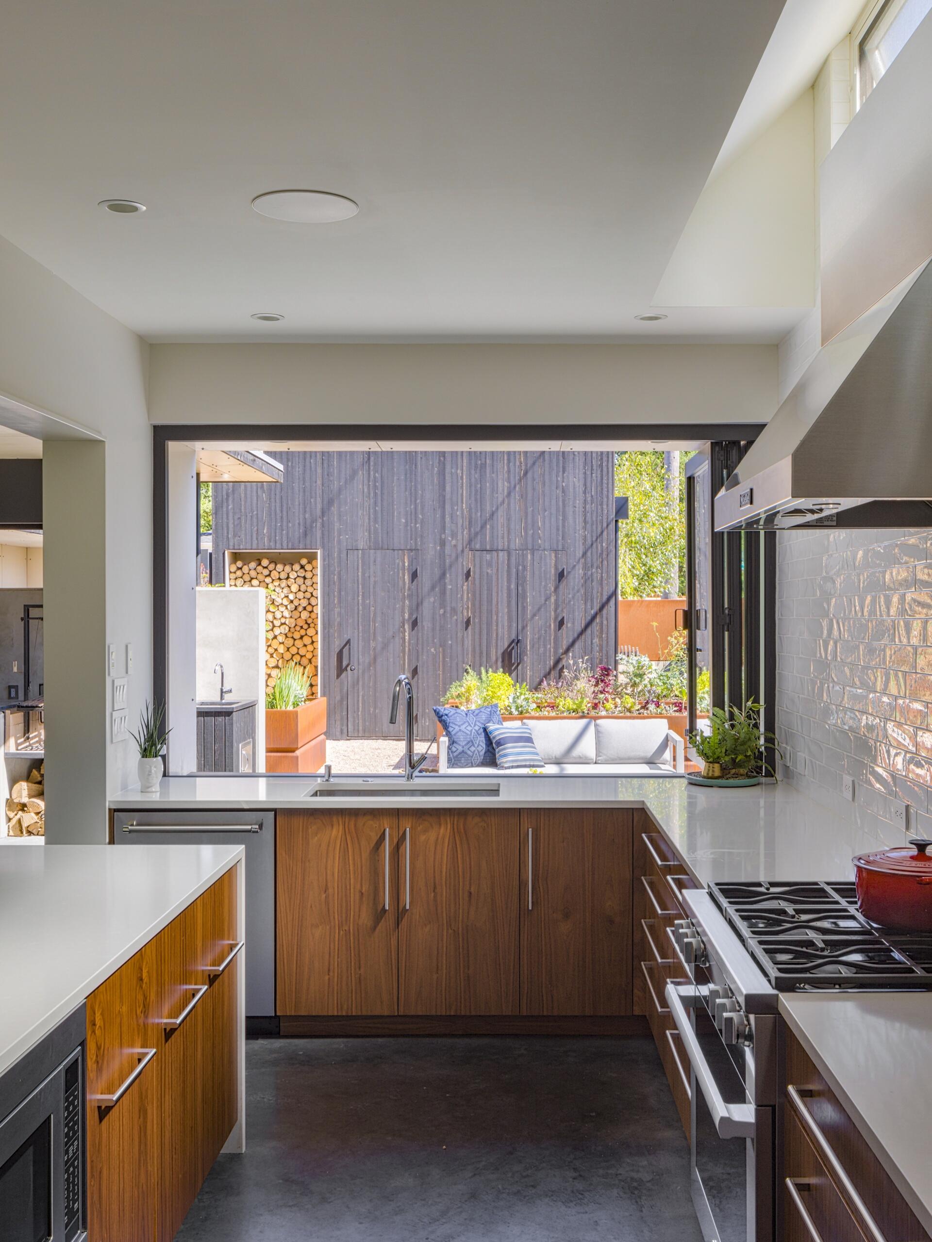 The kitchen sits at the heart of the southern volume and shares space with the dining area. It is compact but efficient, with direct access to the garden outside via a pass-through window. Clerestory windows ensure consistent, indirect light throughout the day while preserving privacy from the street.