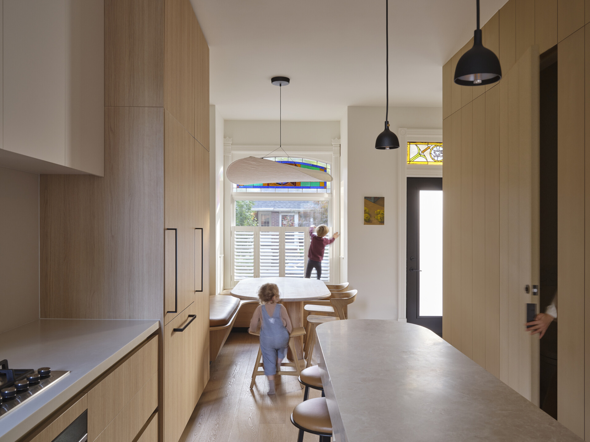 Get inspired by this light-filled kitchen with a cantilevered marble island, oak cabinetry, and clever storage solutions in a narrow urban footprint.
