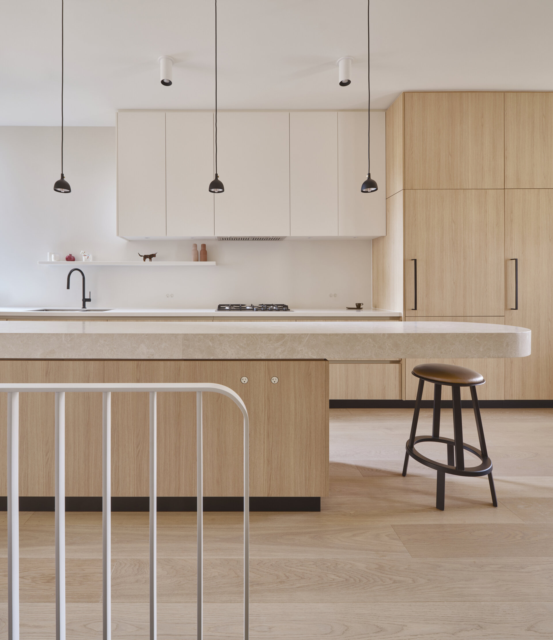Get inspired by this light-filled kitchen with a cantilevered marble island, oak cabinetry, and clever storage solutions in a narrow urban footprint.