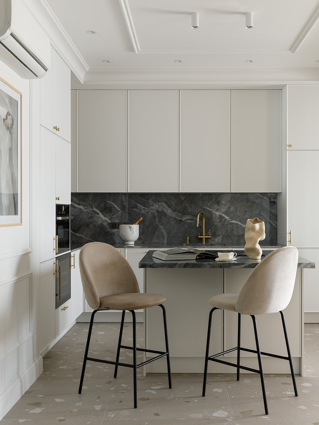 A sculptural, custom-designed kitchen blends function and elegance with seamless cabinetry, natural marble, and sleek Asko appliances. A mirror subtly enhances the light, while a matching island with minimalist stools creates a casual gathering spot. A sliding glass partition offers flexible separation from the dining area.
