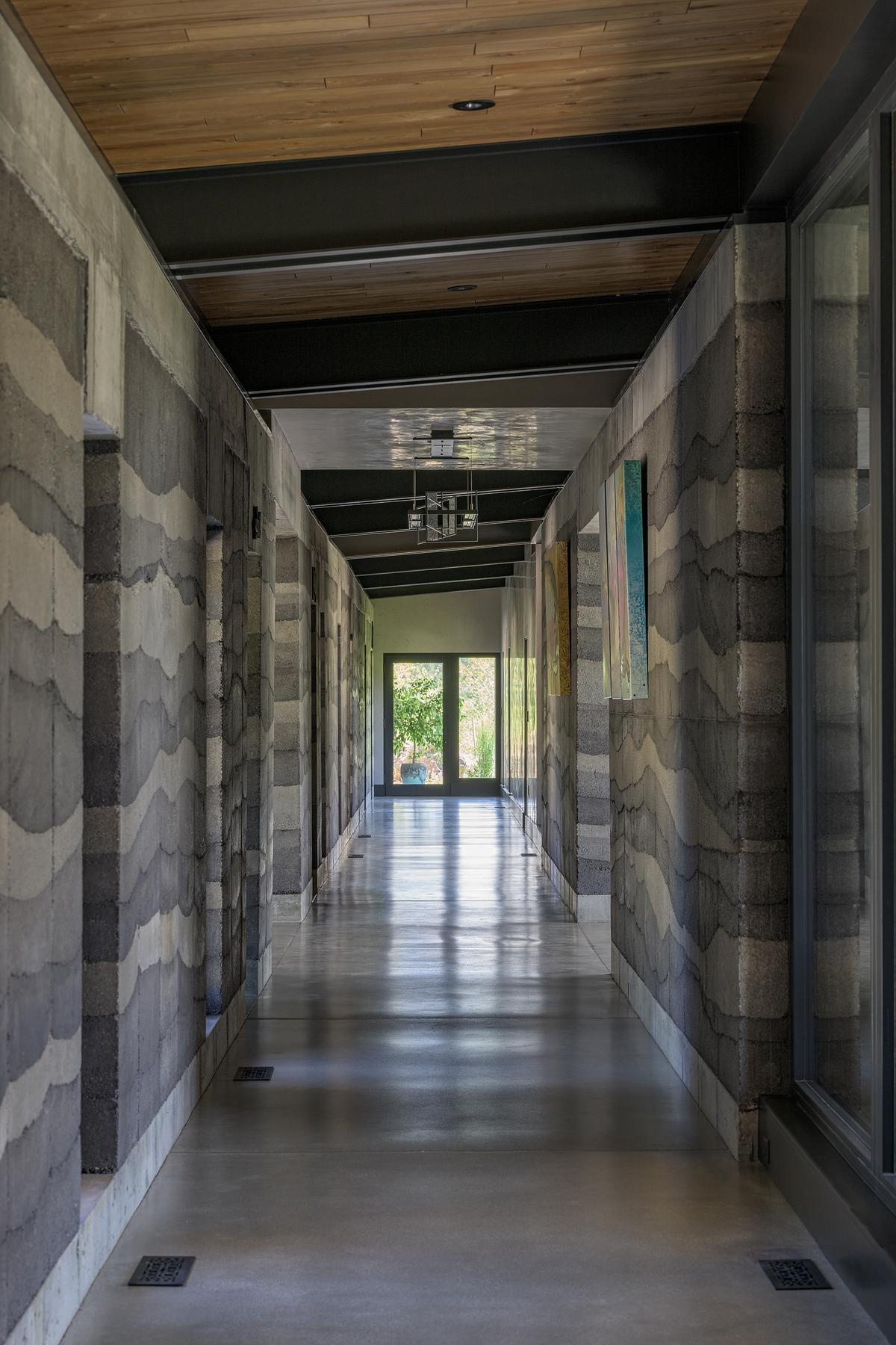 Inside, rammed earth walls, floor-to-ceiling windows, and polished concrete floors, create a unique interior look in this modern mountain house.