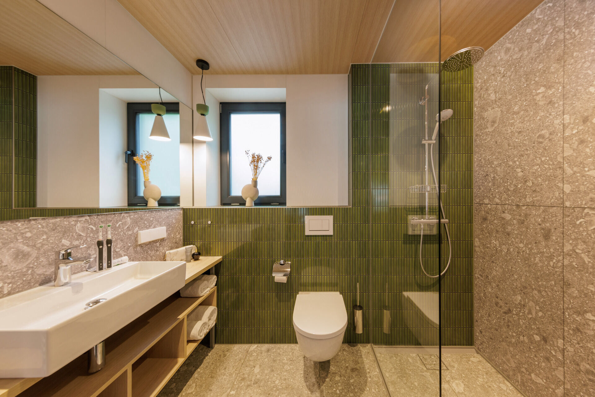 Soft tones and natural textures give the bathroom in this modern prefab cottage a calming, wellness-inspired feel.