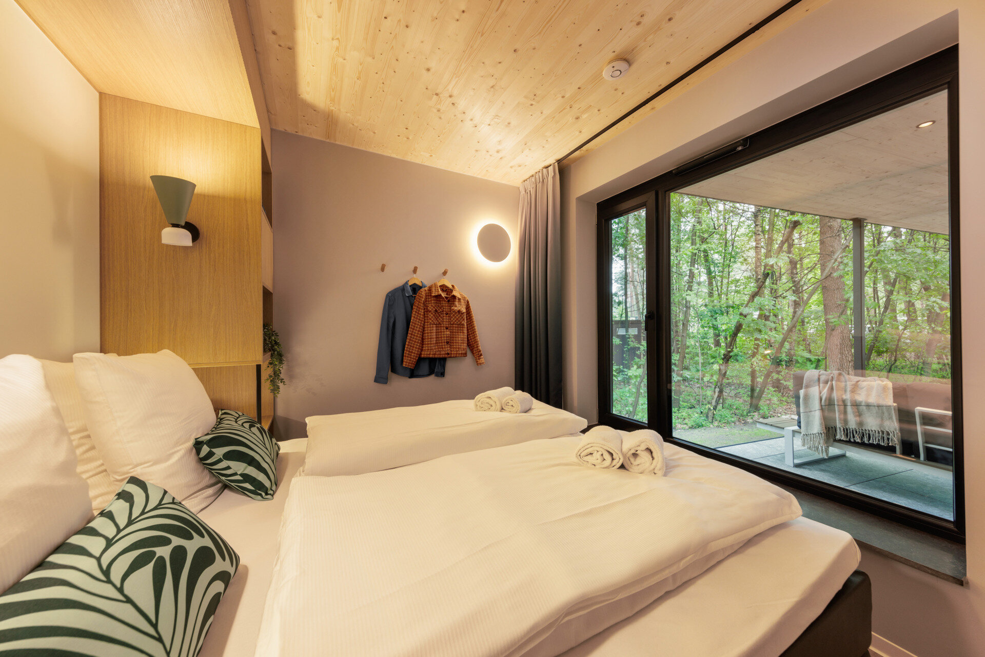 The bedrooms in this modern prefab cottage embrace natural light and wood finishes, creating a tranquil, grounded place to rest.