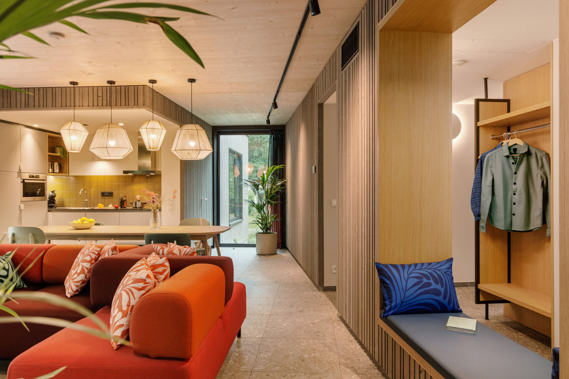 Inside this modern prefab cottage, a flexible corner sofa and oversized dining table anchor an open-plan space designed for comfort and togetherness.