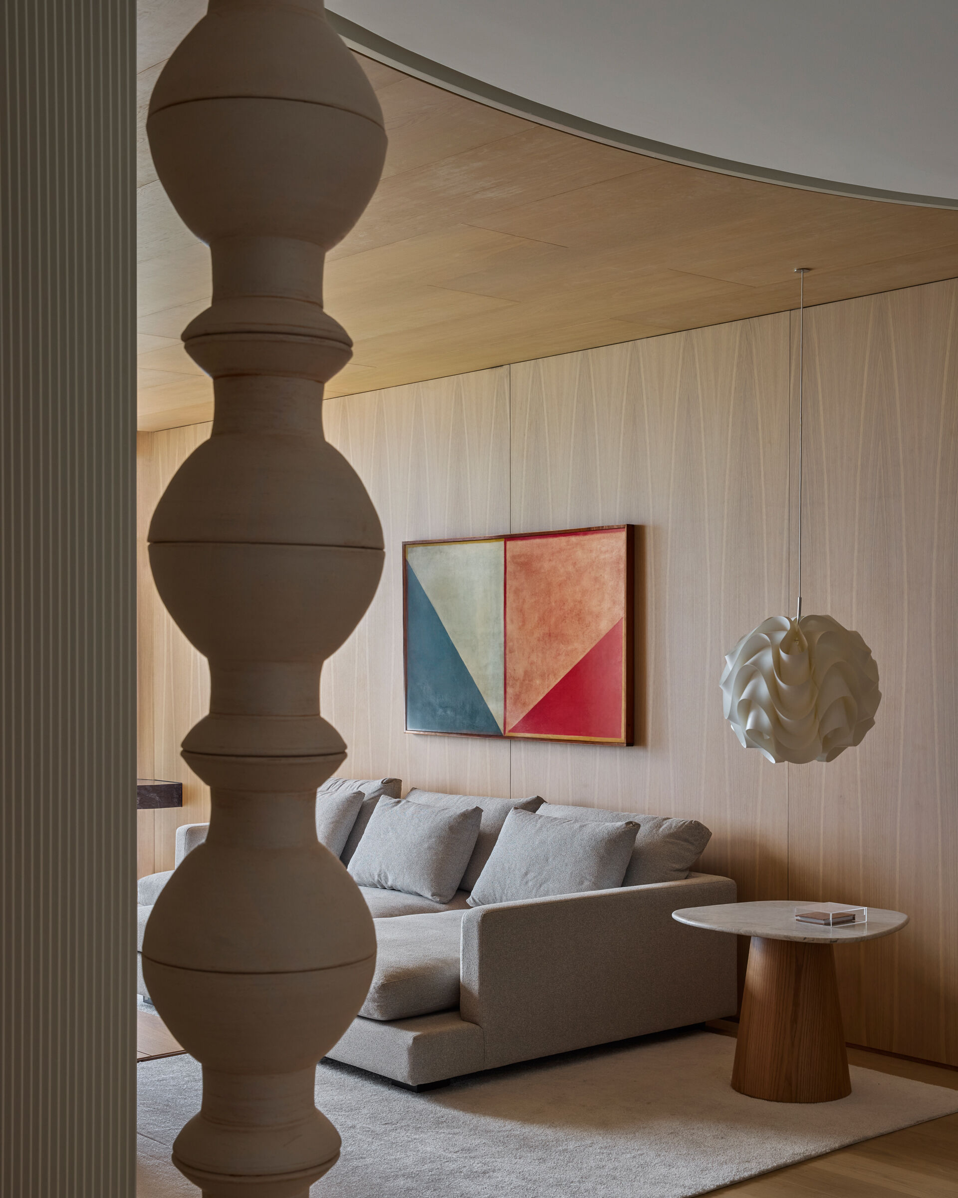 This modern TV room is located on the lower floor, along with the bedrooms and bathrooms. Natural wood cabinetry brings warmth to the TV room, supporting the calm atmosphere of the private level, while a desk runs along the wall facing out towards the views.